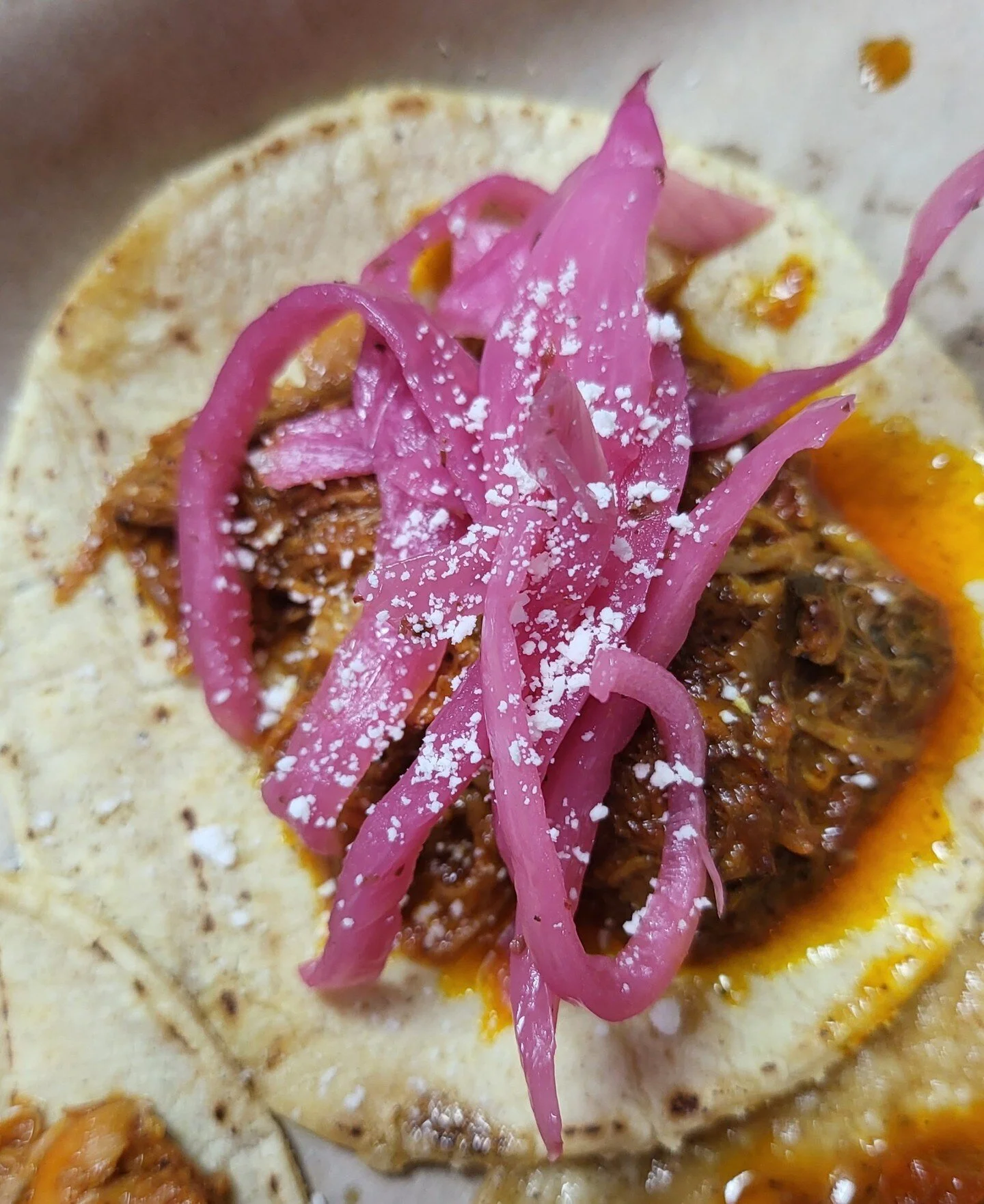 Cochinita (GF). Yucatan style pulled pork with achiote/topped with pickled red onions