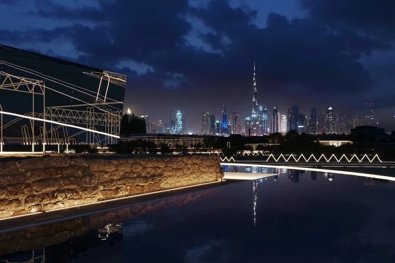 Jumeirah Archaeological Square · Jumeirah — the see-through façade at night, the skyline beyond the water