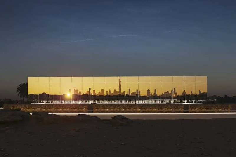 Jumeirah Archaeological Square · Jumeirah — the mirrored façade at sunset, the skyline reflected in it