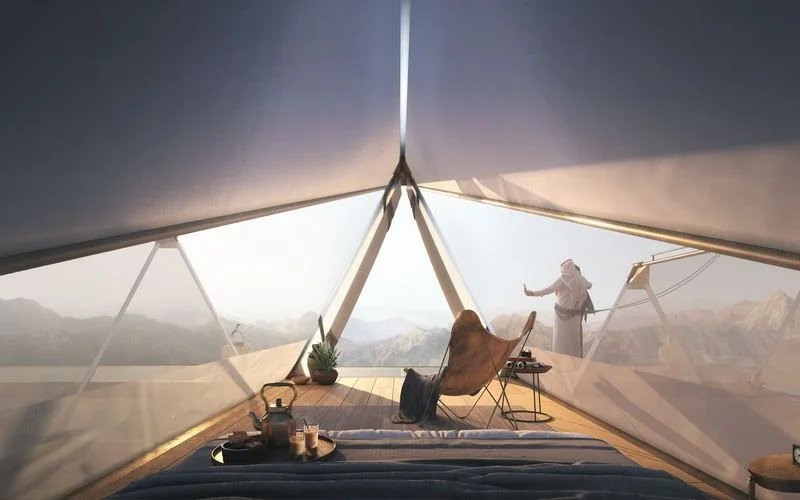 The Floating Retreat · Sharjah mountains — inside a suspended room, a guest looking out over the mountains