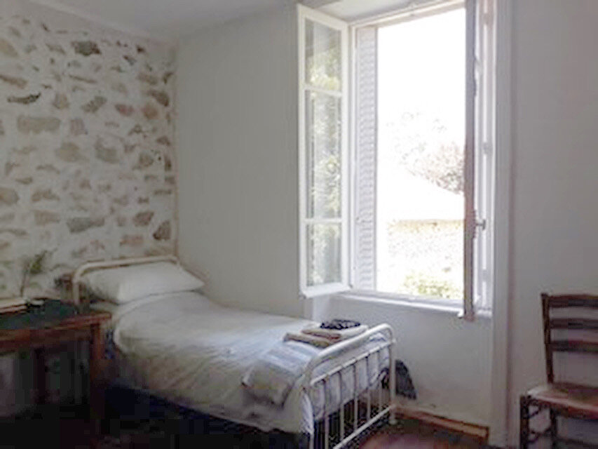 Back bedroom with two single beds and view onto the garden.