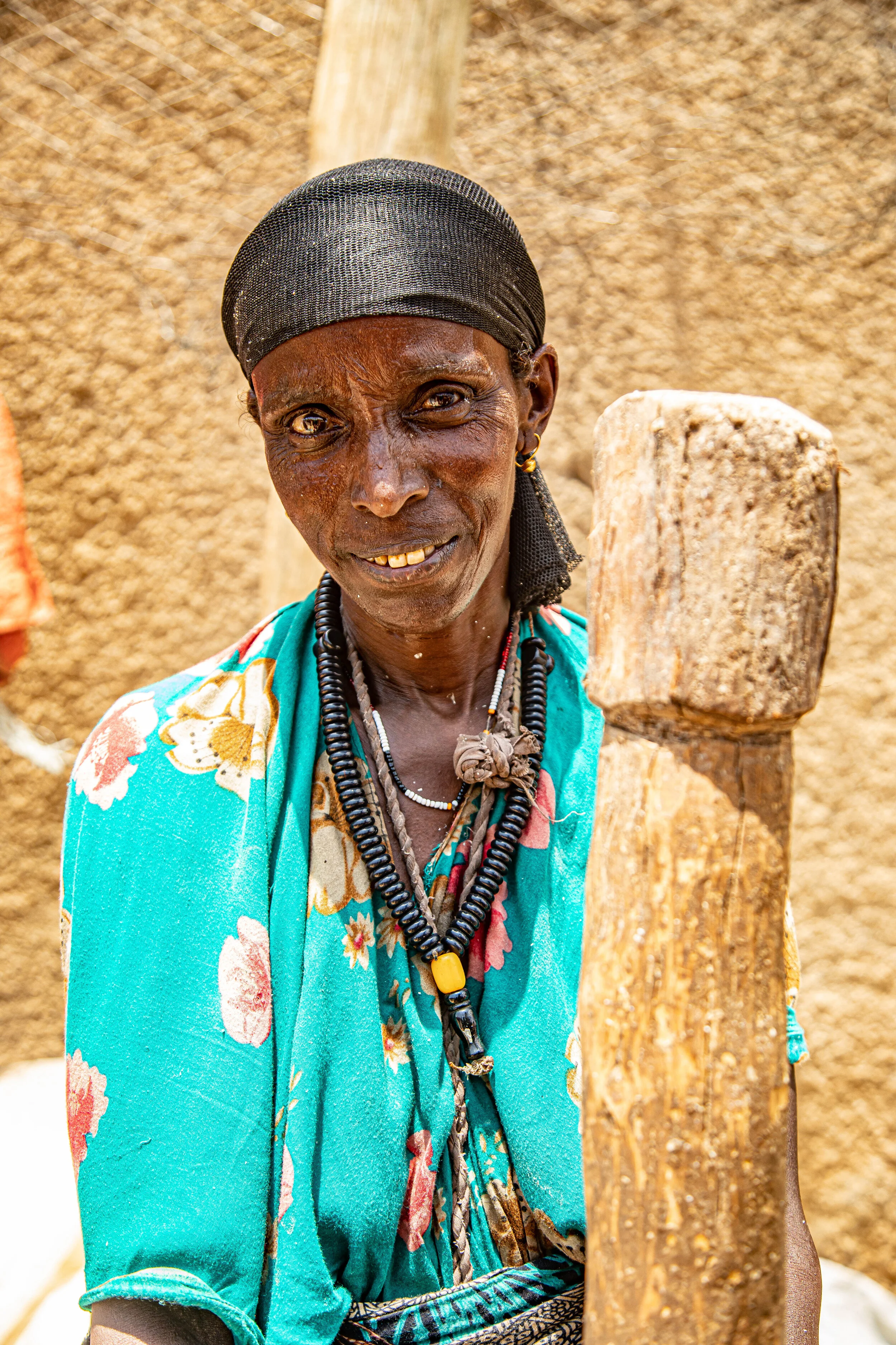  A Somali woman poses for a photo while holding a pestle used for grinding maize. 