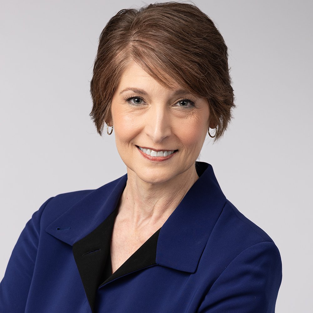 business woman wearing blue jacket and smiling while posing for her professional headshot