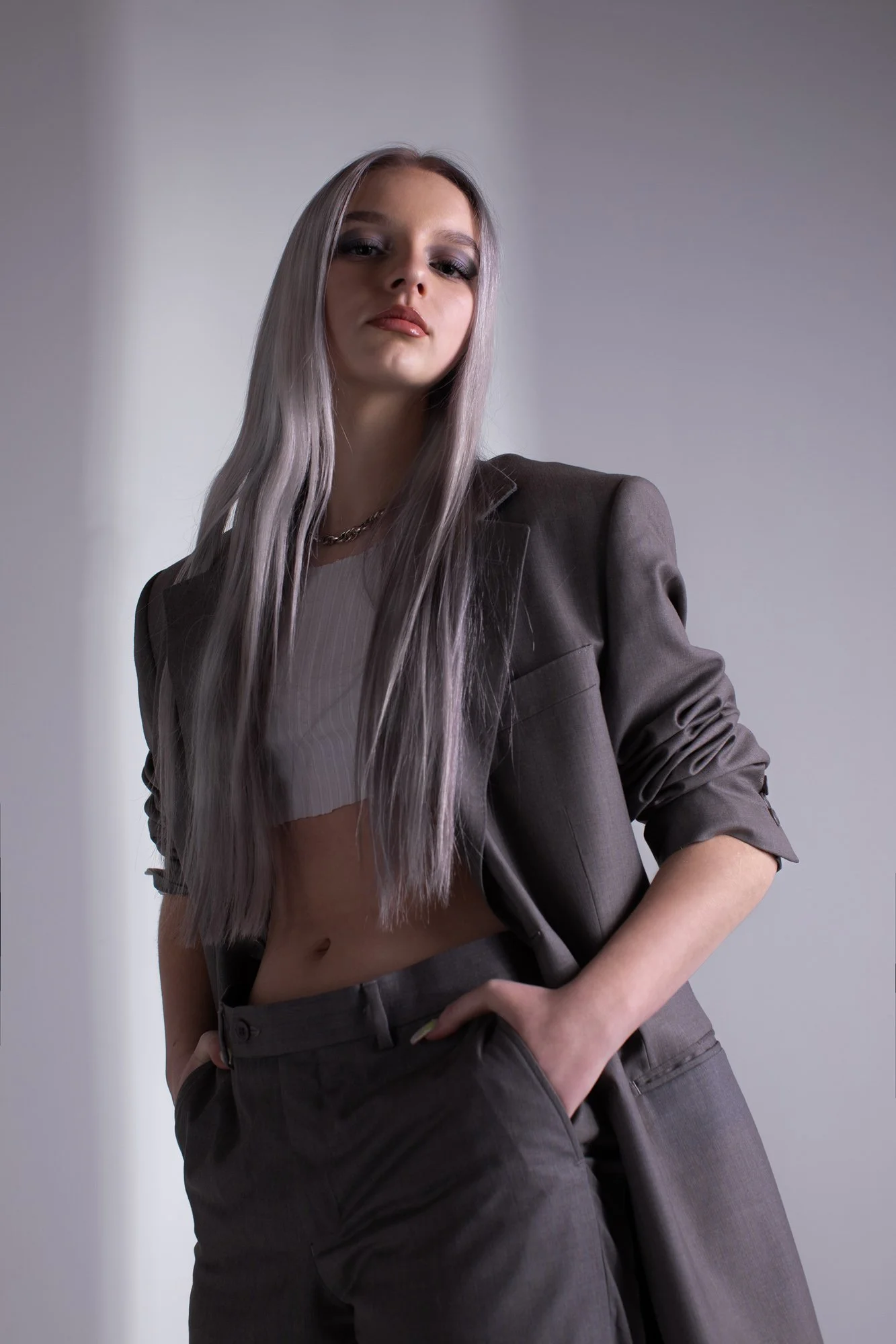 moda kobieta z długimi włosami w garniturze pozuje w studio do sesji portretowej