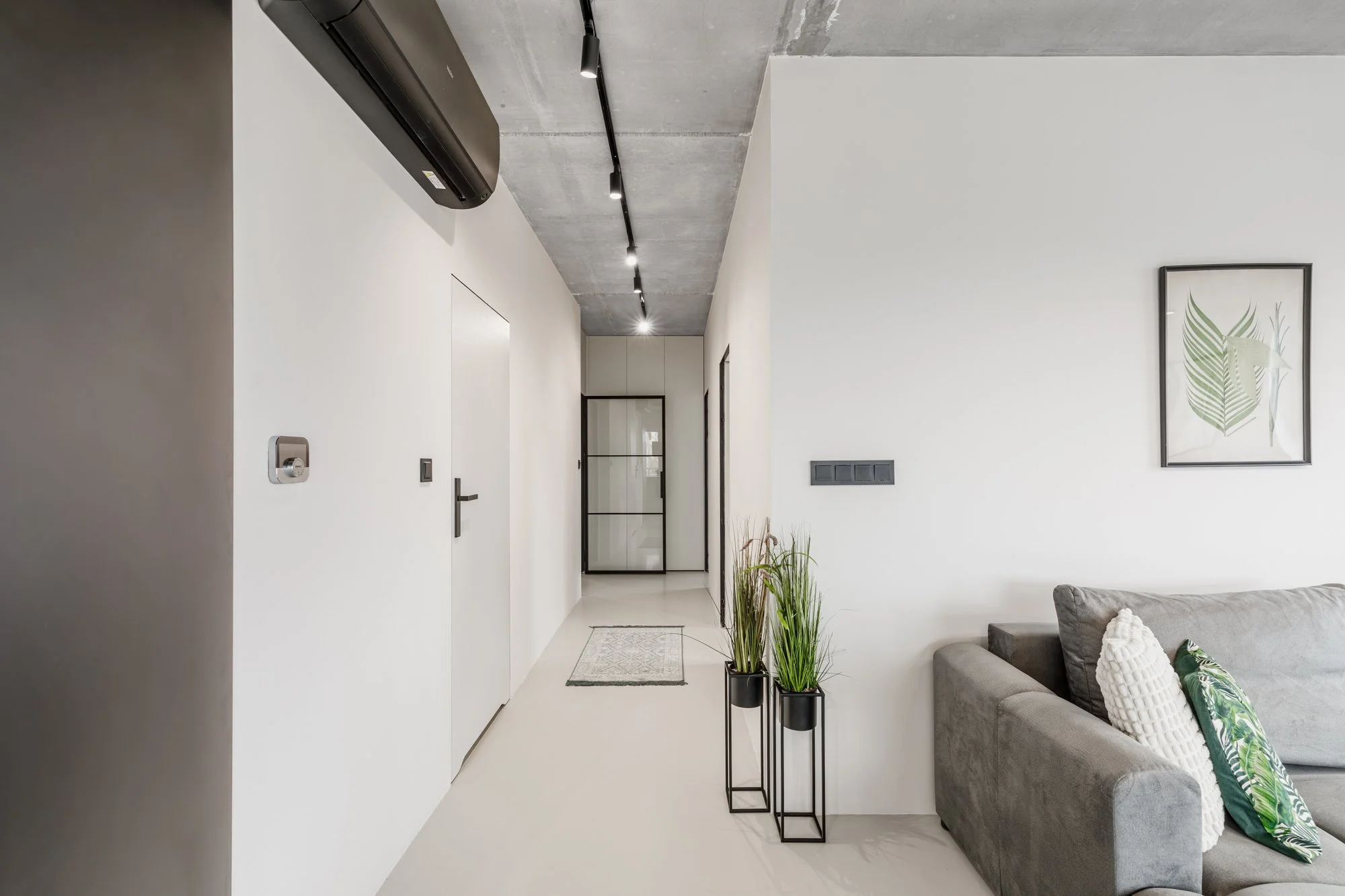 sesja nieruchomości, szare wnętrze typu loft, beton i ciemne meble, minimalizm