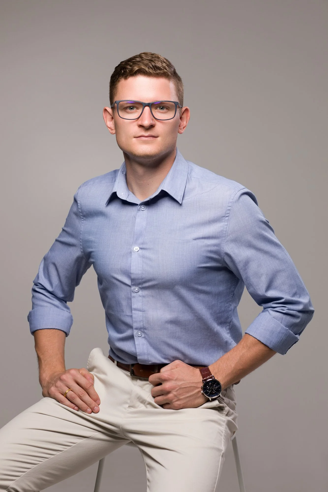 sesja wizerunkowa młodego mężczyzny w błękitnej koszuli i jasnych spodniach
