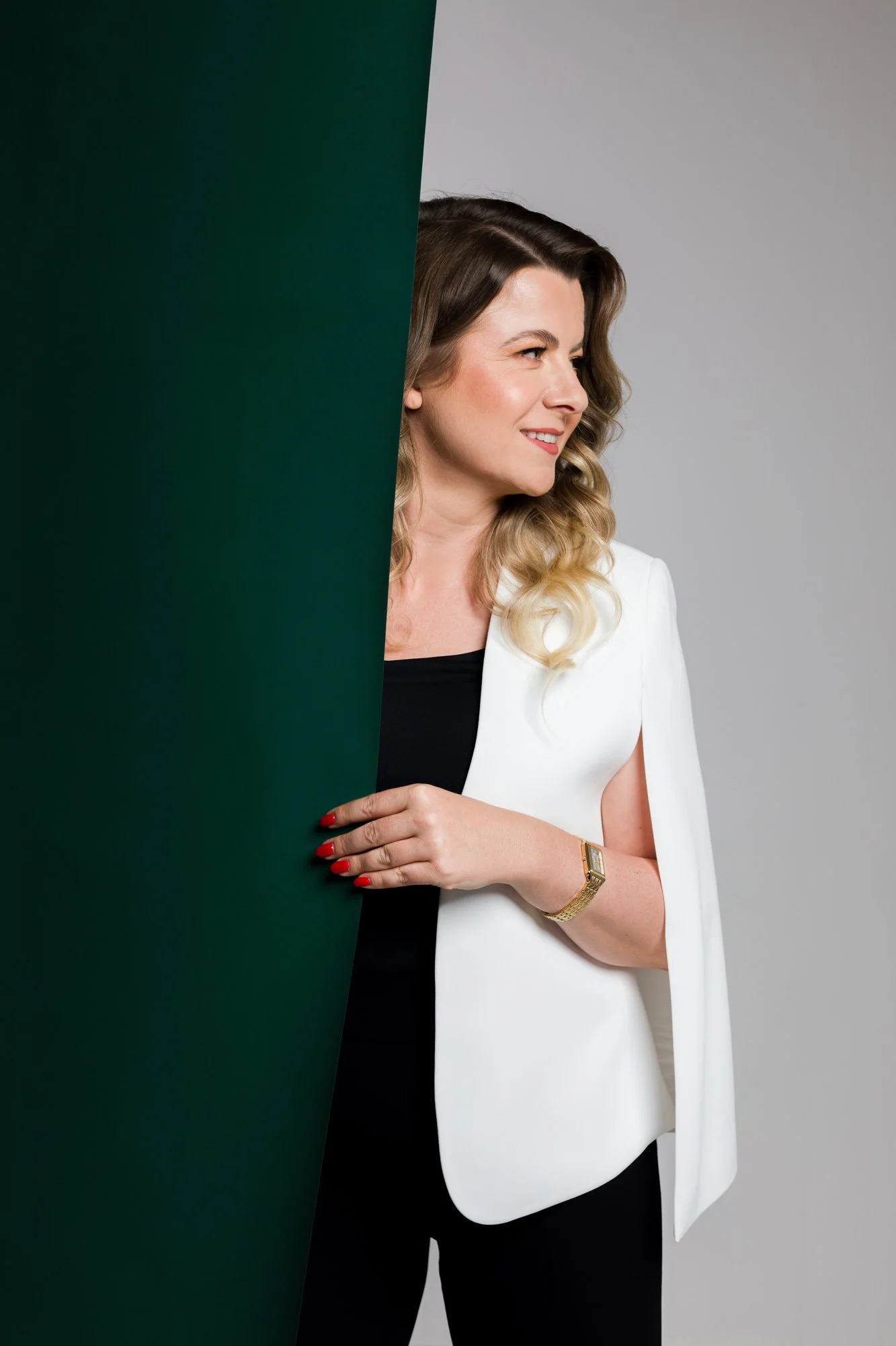 bizneswoman pozuje w studio do sesji wizerunkowej, w białej marynarce