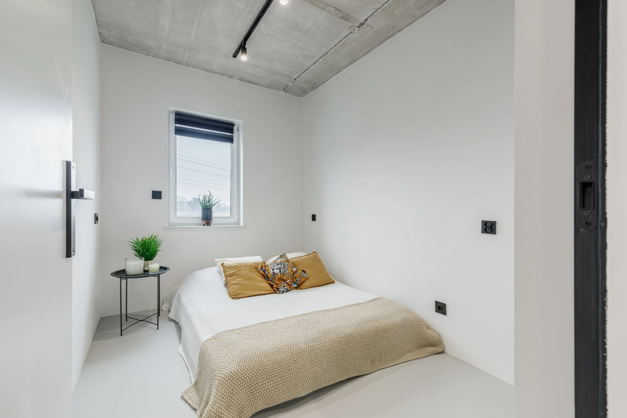 sesja nieruchomości, szare wnętrze typu loft, beton i ciemne meble, minimalizm