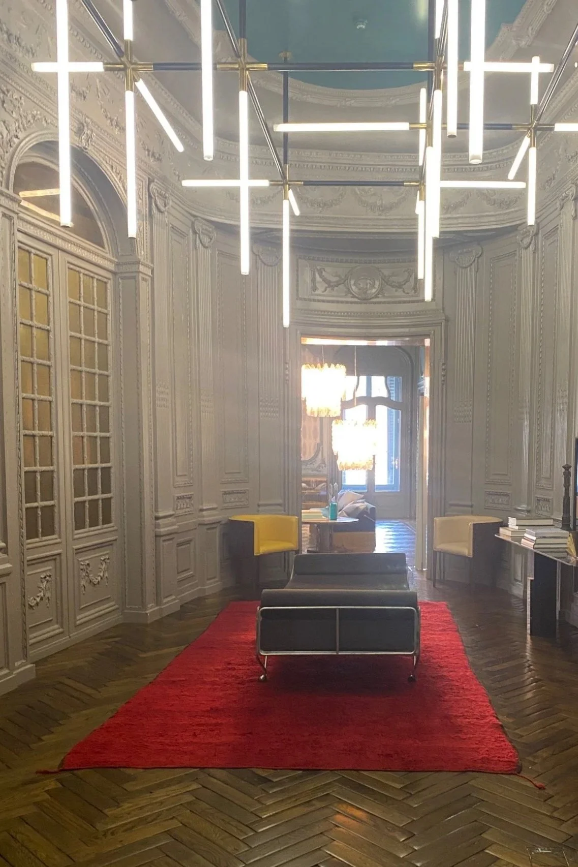 Hallway inside Palazzo Fendi in Rome, with ornate paneling, geometric lighting, and a red rug. Photographed in June 2023.
