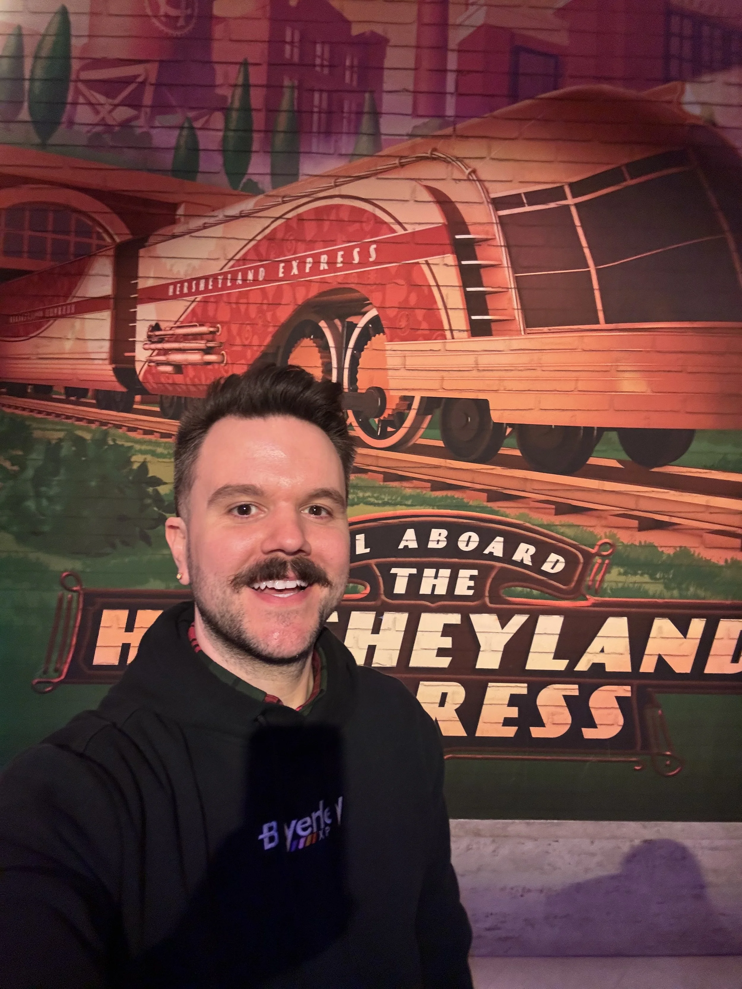 Selfie of Owner in front of Hersheyland Express mural.
