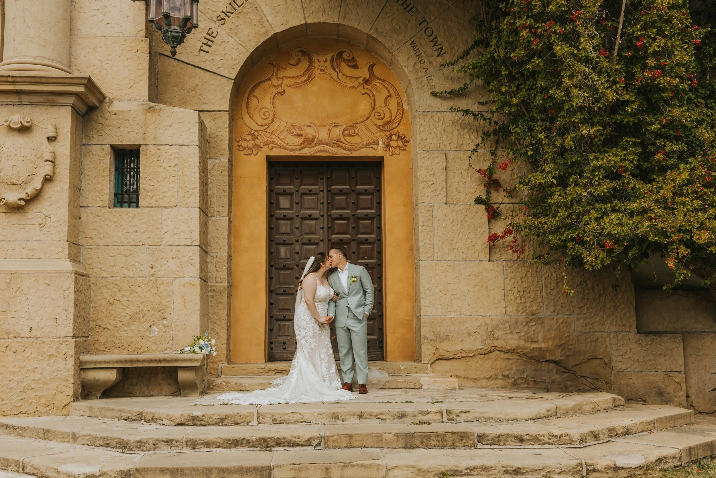 Newlyweds stand in front of courthouse and kiss. Located in Seattle, WA.