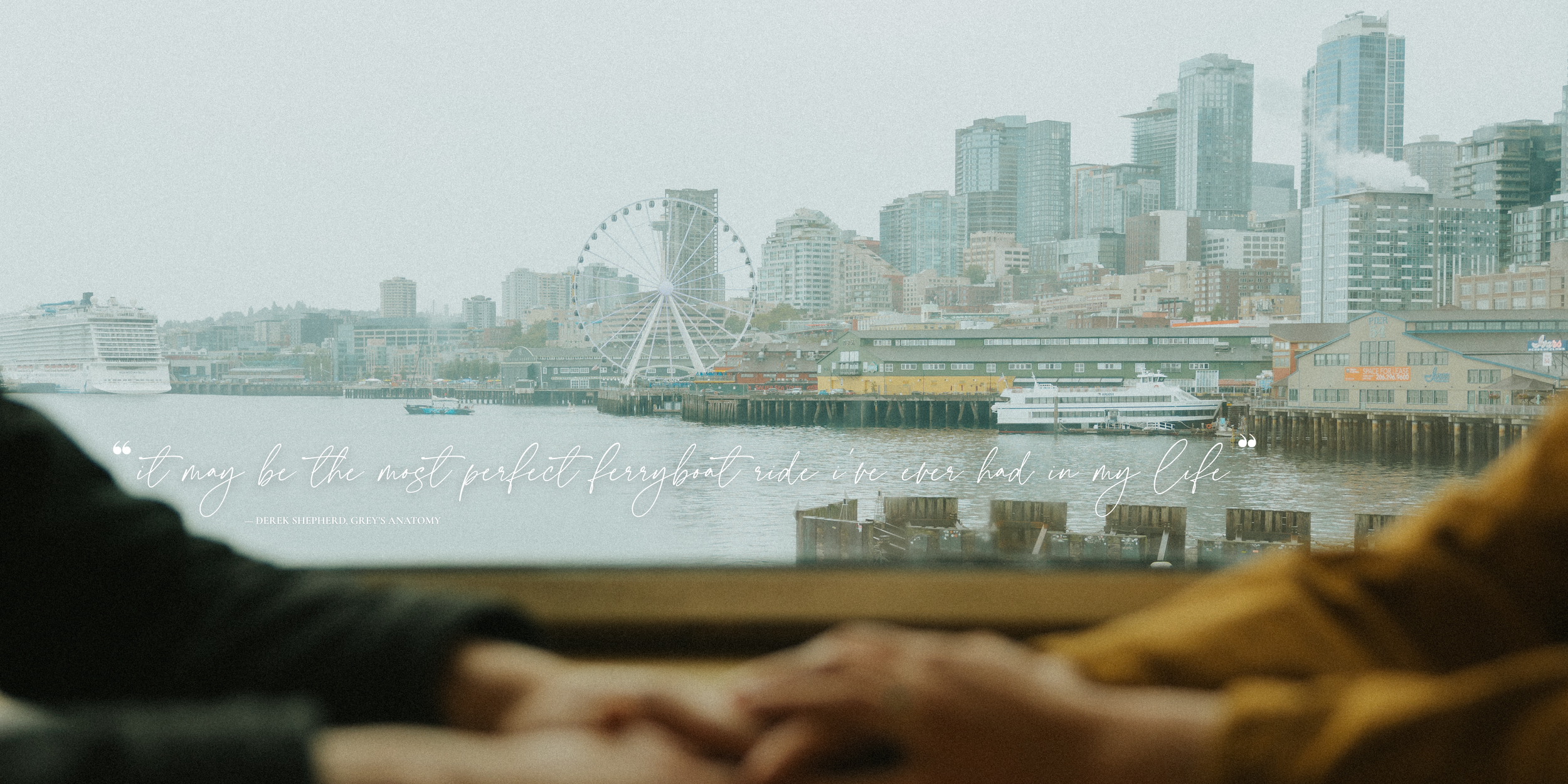 Photo of the Seattle cityscape featuring the Seattle Great Wheel. Photo has script font text overlayed and reads "it may be the most perfect ferryboat ride I've ever had in my life," said by Derek Shepherd in Season 11 of Grey's Anatomy.