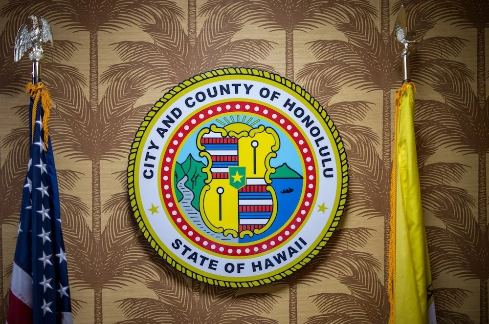 Picture of the City logo and flags at the entrance of Honolulu Hale