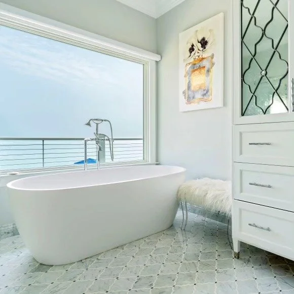 Relaxing is a given with views of the Sound in this primary bathroom. Custom Carrara/Thassos flooring in an arabesque pattern augments the lush details of this spa space.
.
.
#spabath #bathroomdecor #bathdesign #bathroomtiles #designerbath #basketwea