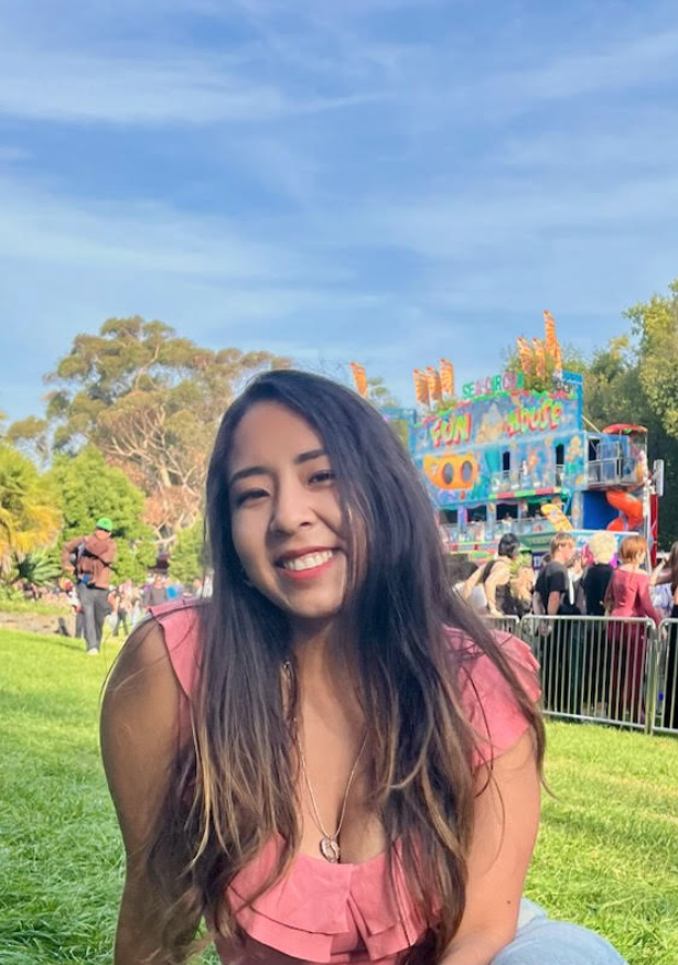 Person with long hair at the park smiling