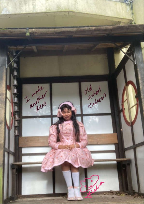 Alisha Lawrence in a classic lolita pose in a sweet lolita Peter rabbit dress in a Japanese garden