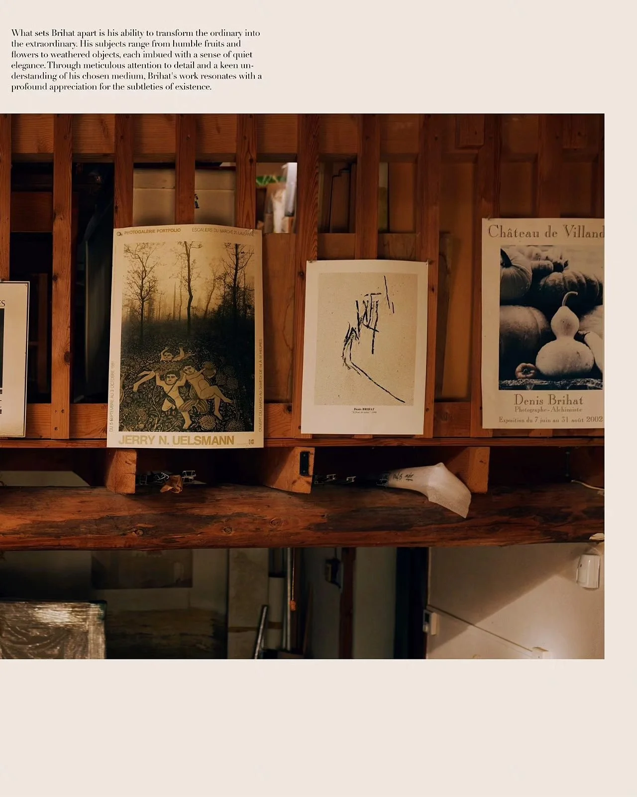 Exhibition display with three art posters on a wooden wall, including a tree scene, an abstract sketch, and pumpkins, in a gallery or studio setting.