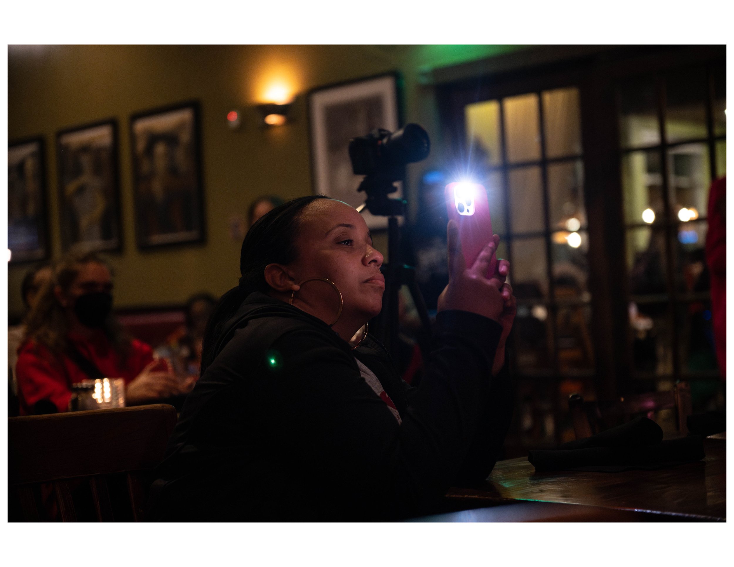   Parent captures photo at an open mic event hosted by Words Beats &amp; Life Inc. at Busboys and Poets in Washington, DC. Photographer/Victoria Ford  