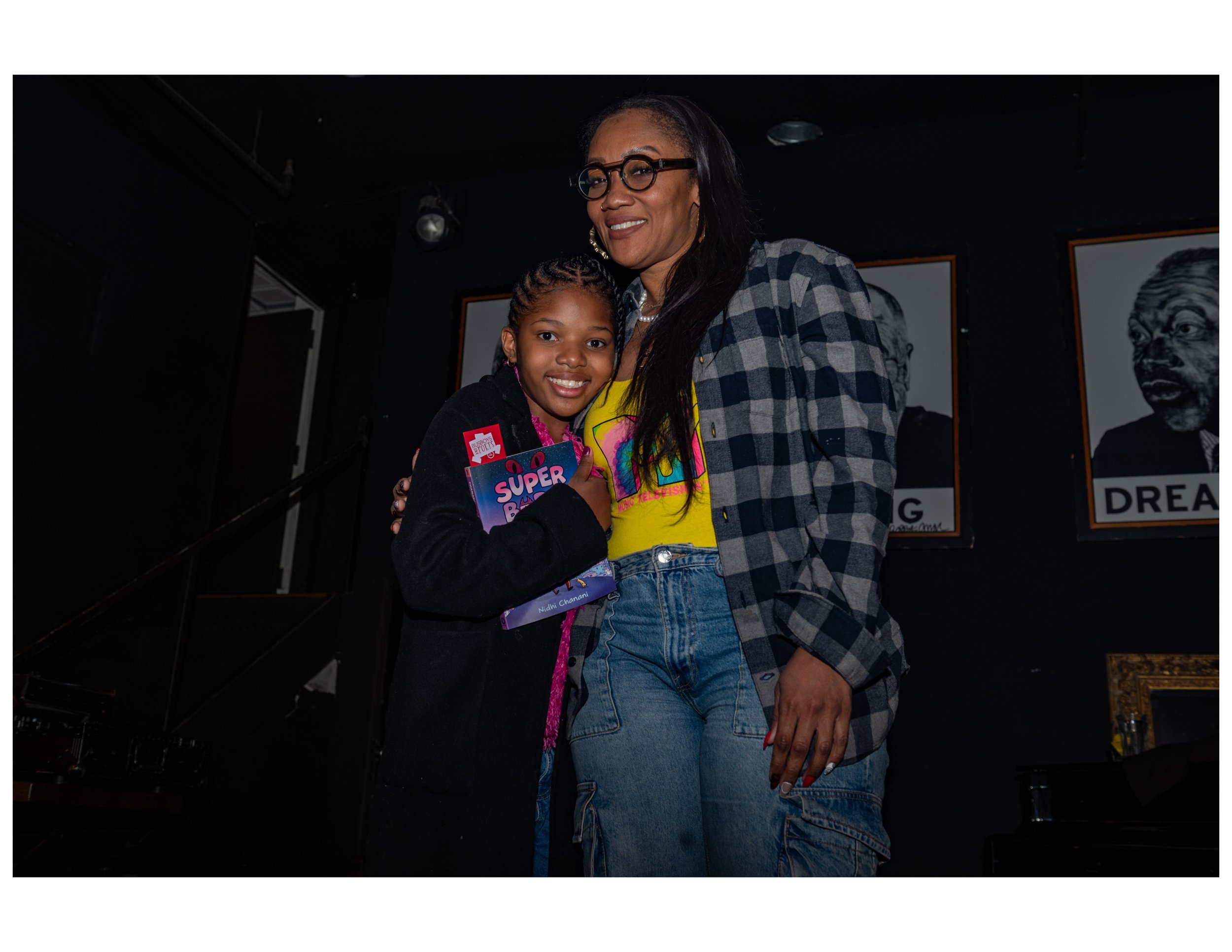   Parent and participant pose for a photo at an open mic event hosted by Words Beats &amp; Life Inc. at Busboys and Poets in Washington, DC. Photographer/Victoria Ford  