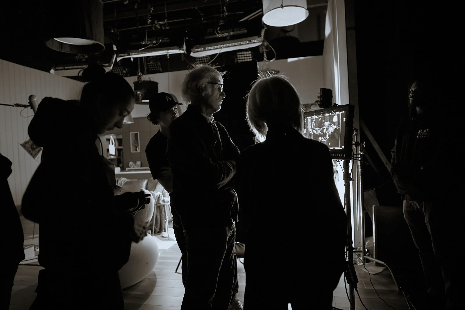 Filmmaking crew working on set with monitor and lighting, behind-the-scenes of film production