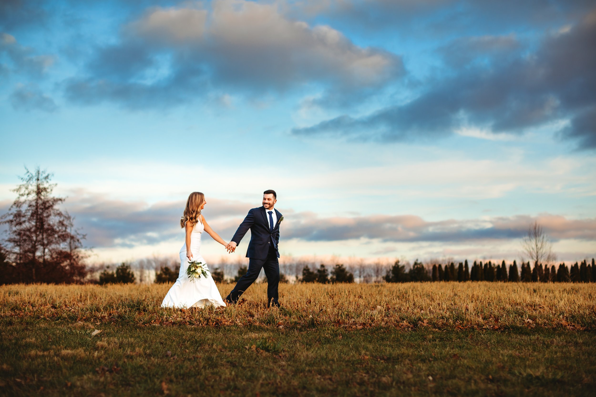  Outdoor portrait of a newlywed couple walking through a field in Illinois by Teala Ward Photography. wedding photography rich dynamic #tealawardphotography #tealawardweddings #LaSalleIllinois #IronwoodontheVermillion #weddingphotographyIL 