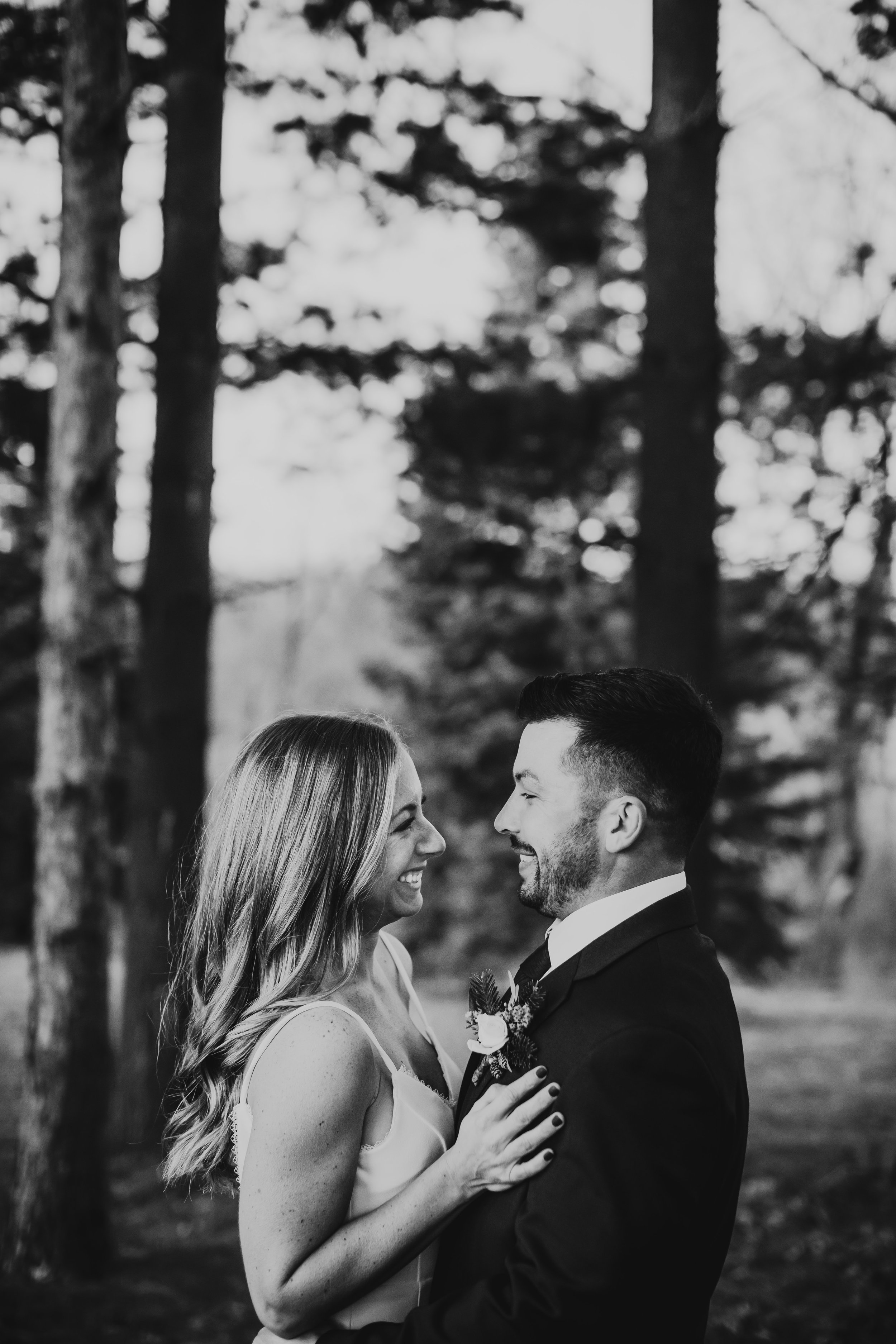  The bride and groom laugh while looking lovingly at one another by Teala Ward Photography. spaghetti strap wedding gown black suit IL weddings #tealawardphotography #tealawardweddings #LaSalleIllinois #IronwoodontheVermillion #weddingphotographyIL 