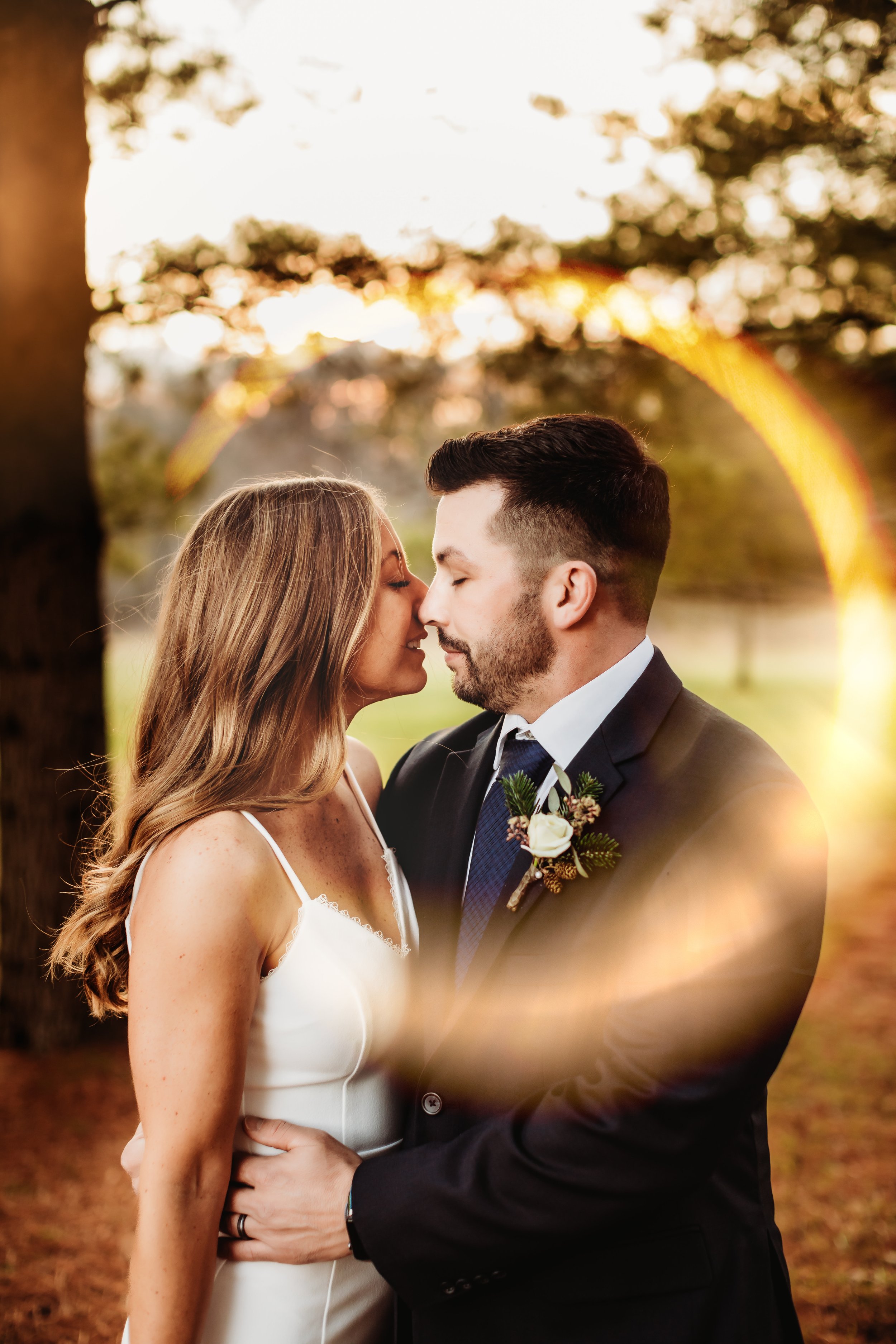  Professional photographer Teala Ward Photography captures a bride and groom kissing with a golden sun ring around them. golden sun ring bridals #tealawardphotography #tealawardweddings #LaSalleIllinois #IronwoodontheVermillion #weddingphotographyIL 