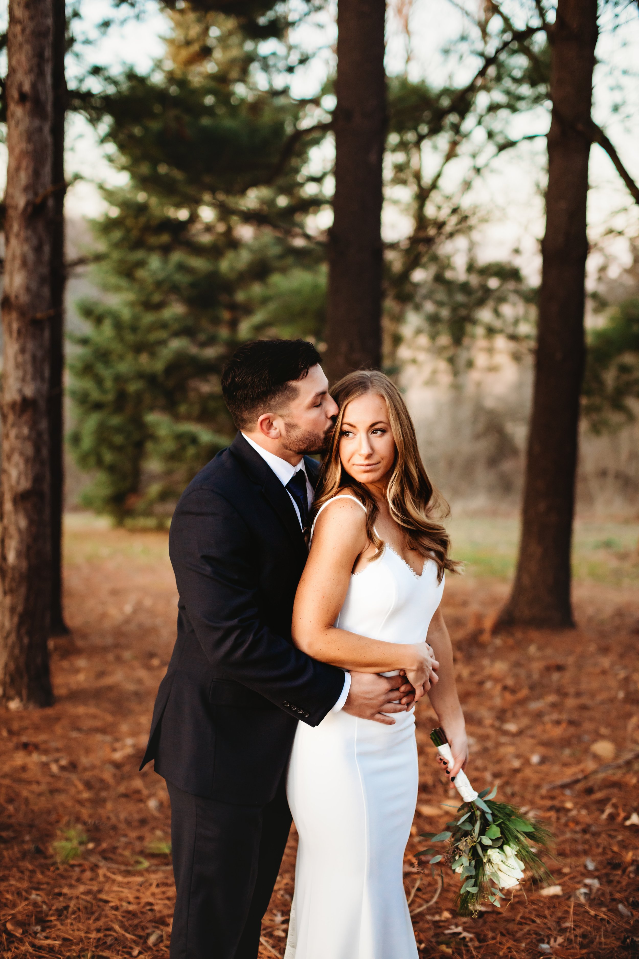 Teala Ward Photography captures a new husband and wife on their wedding day snuggling close. black suit winter wedding misty bridal portraits #tealawardphotography #tealawardweddings #LaSalleIllinois #IronwoodontheVermillion #weddingphotographyIL 