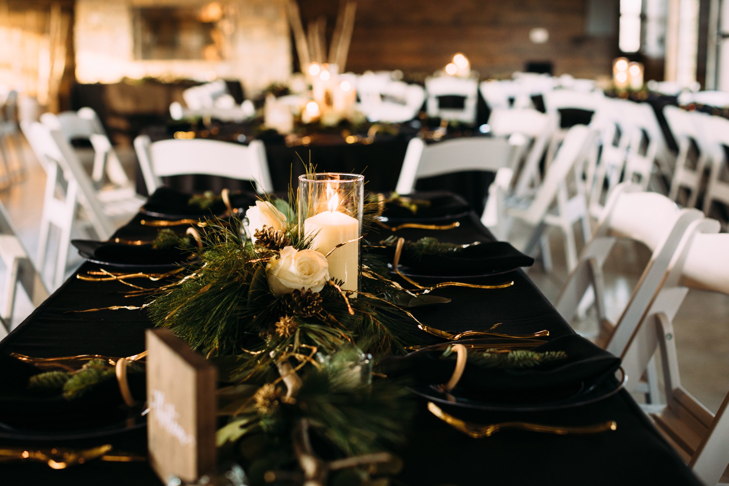  Teala Ward Photography captures a wedding table set up with black tablecloths, candles, and gold silverware. winter wedding table decor gold #tealawardphotography #tealawardweddings #LaSalleIllinois #IronwoodontheVermillion #weddingphotographyIL 
