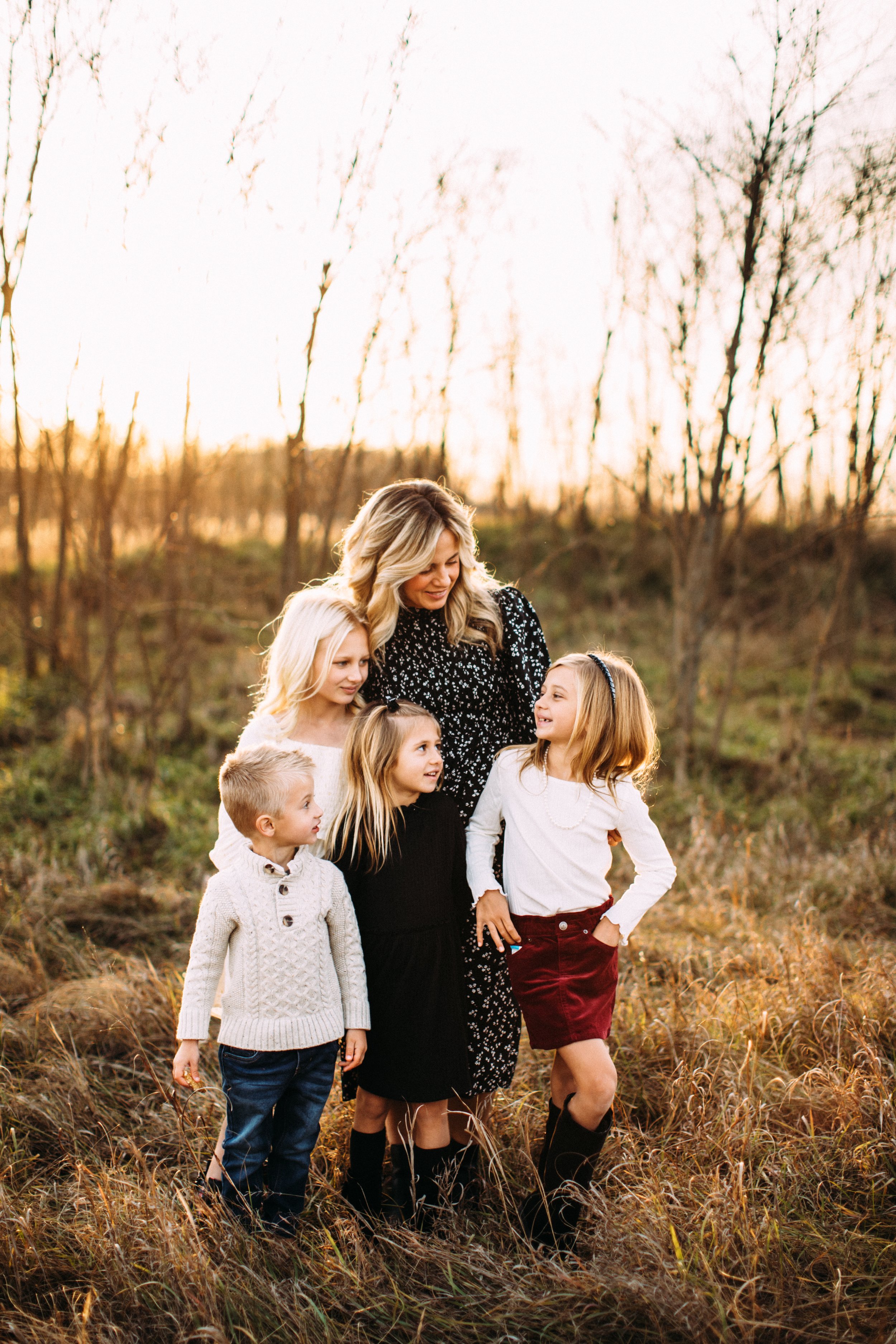  A mother with her four children smiles at one another in a grass field at Buffalo Rock by Teala Ward Photography. mommy and four kids #TealaWardPhotography #TealaWardFamilies #StarvedRockStatePark #BuffaloRockPhotographers #UticaIllinoisphotographer