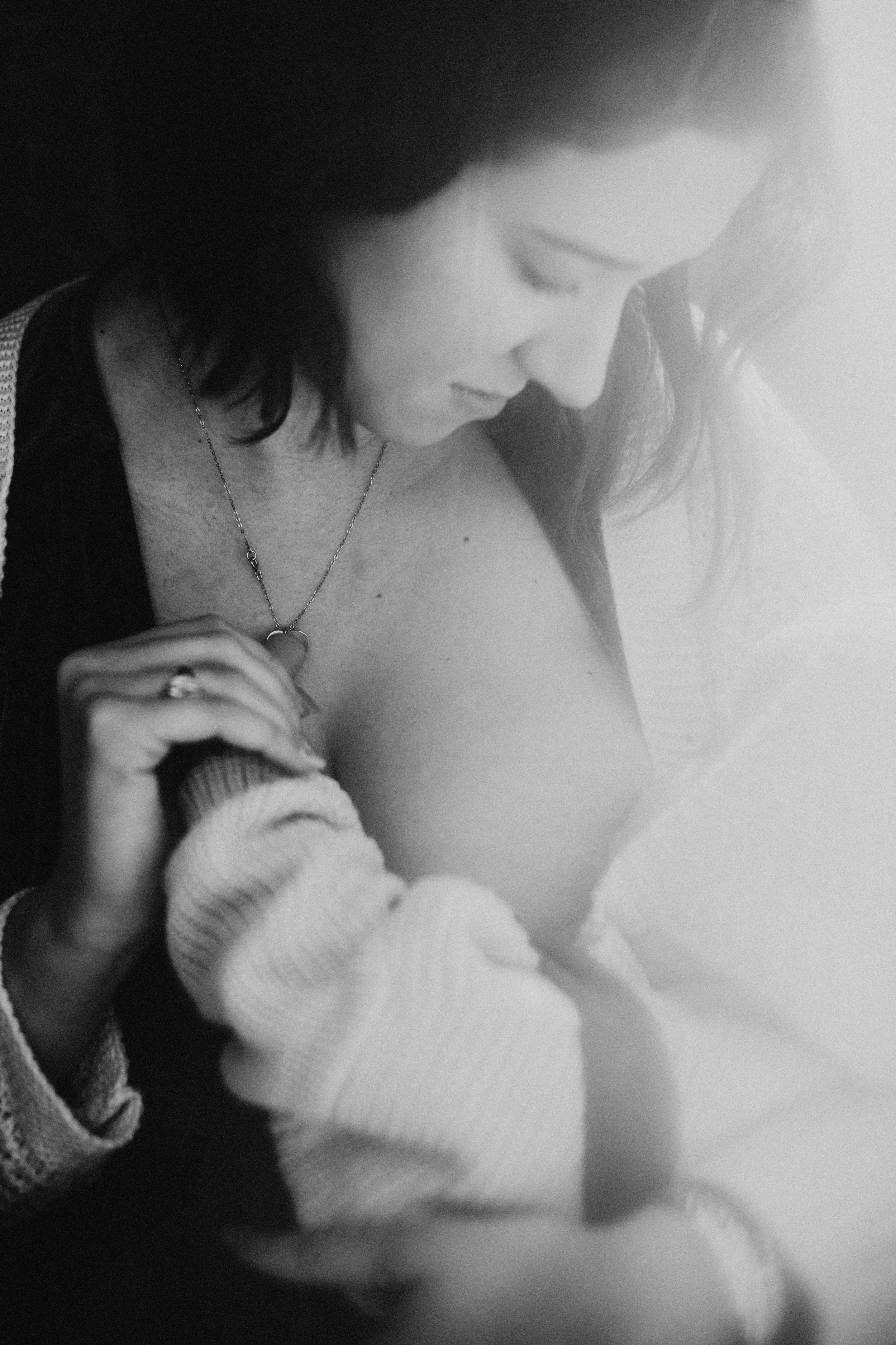  Black and white portrait of a mother breastfeeding her baby while holding her hand by Teala Ward Photography. breast-feeding #TealaWardPhotography #TealaWardNursing #StarvedRockStatePark #nursingbaby #breastfedbabyphotography #motherandbaby 