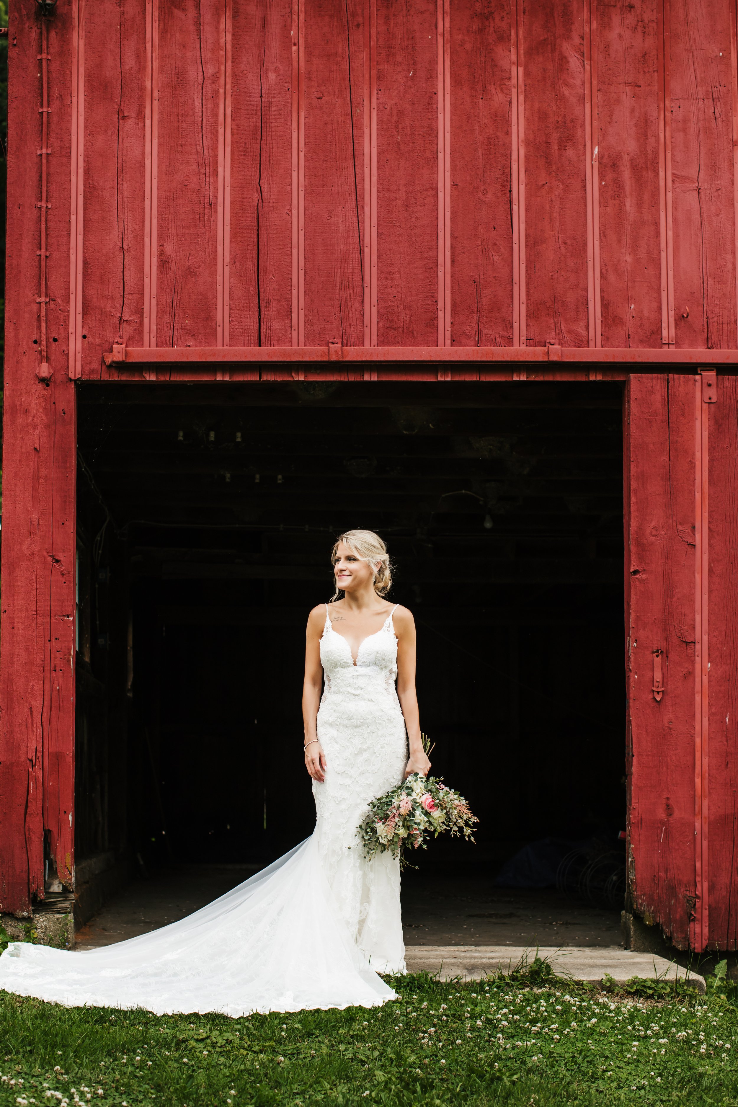  Bridal portraits in front of a red barn. lace wedding dress has a long train bouquet of roses and greenery bride intimate wedding #TealaWardPhotography #illinoisphotographer #princetonillinois #weddingphotographer #intimatewedding 