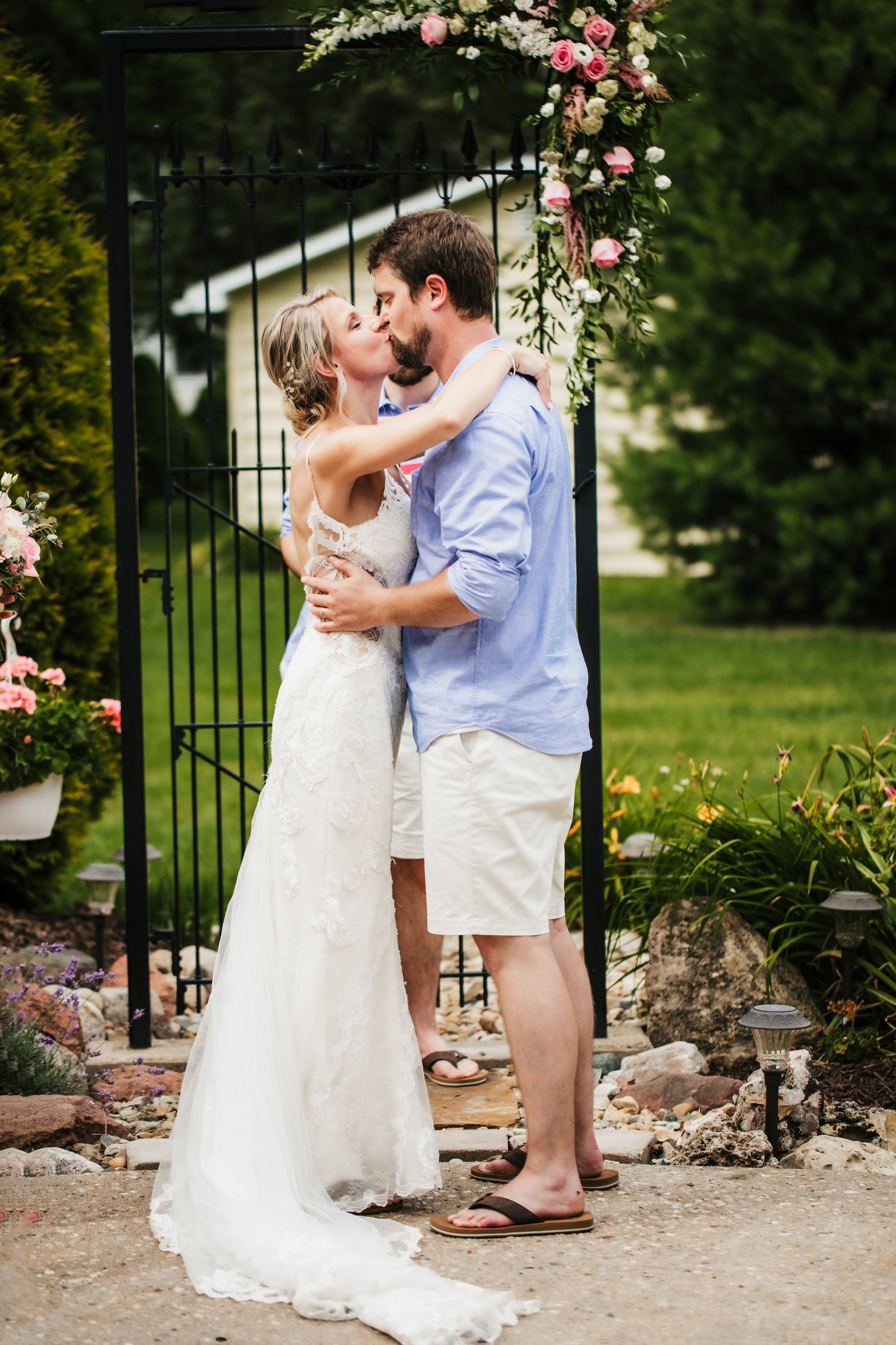  First kiss as husband and wife intimate wedding couple. bridal gown with lace and long train husband in blue button up and shorts #TealaWardPhotography #illinoisphotographer #princetonillinois #weddingphotographer #intimatewedding 