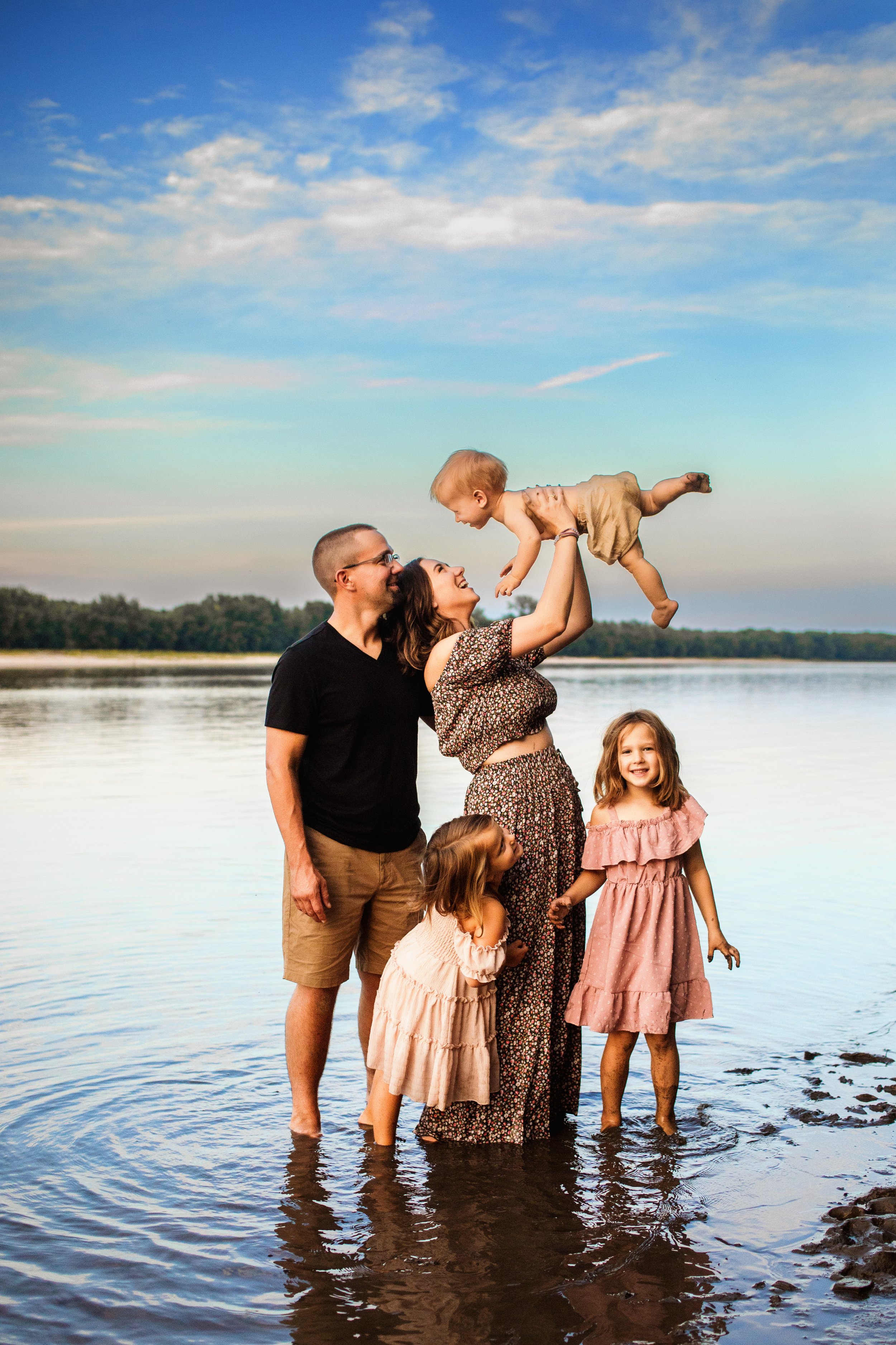  In the Illinois River, a family of five laughs together in front of a moody sky by Teala Ward Photography. water family pic #TealaWardPhotography #TealaWardFamilies #IllinoisRiverPhotography #IllinoisFamilyPhotography #familylifestylepics 