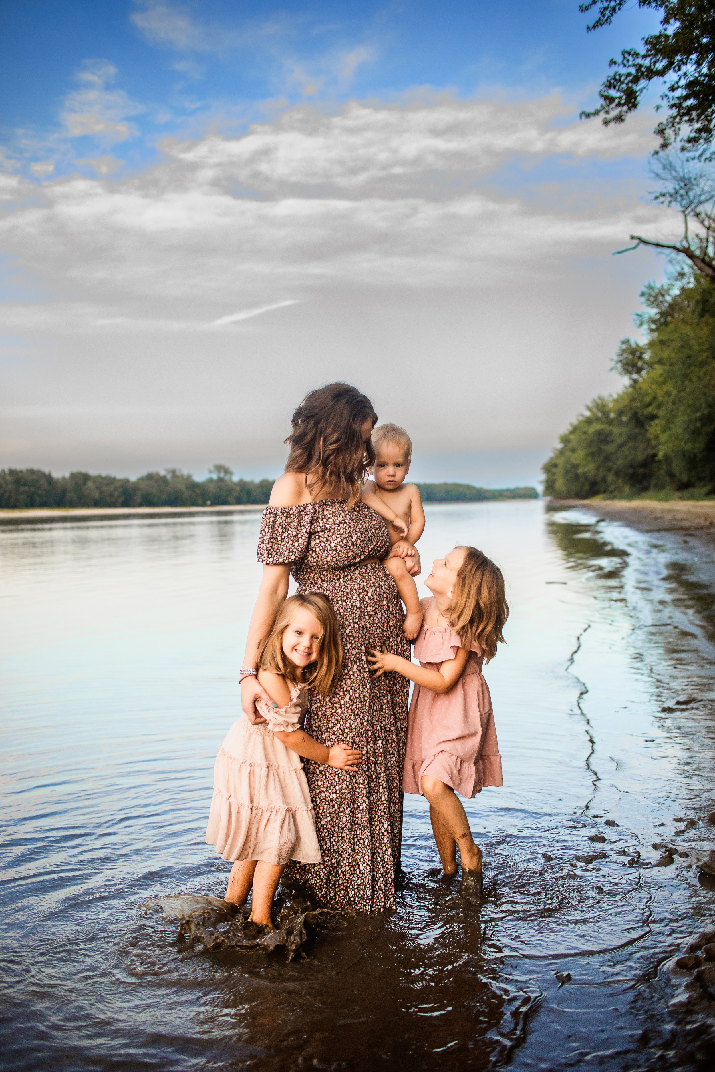  Two little girls run around in the water while hugging their mother by Teala Ward Photography. family photography Illinois #TealaWardPhotography #TealaWardFamilies #IllinoisRiverPhotography #IllinoisFamilyPhotography #familylifestylepics 