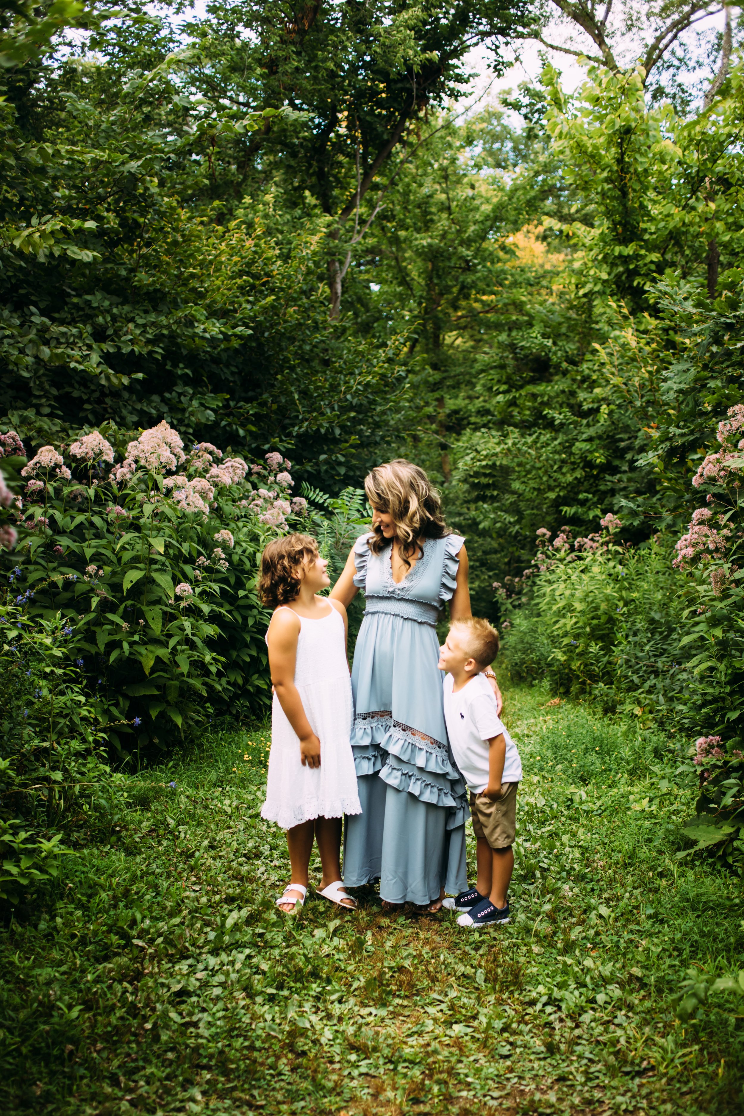  In a beautiful green forest, a mother looks down at her daughter and smiles captured by Teala Ward Photography. mother in blue #motherhood #mommapics #TealaWardPhotography #TealaWardFamilies #IllinoisPhotographers #IllinoisFamilyPhotography 