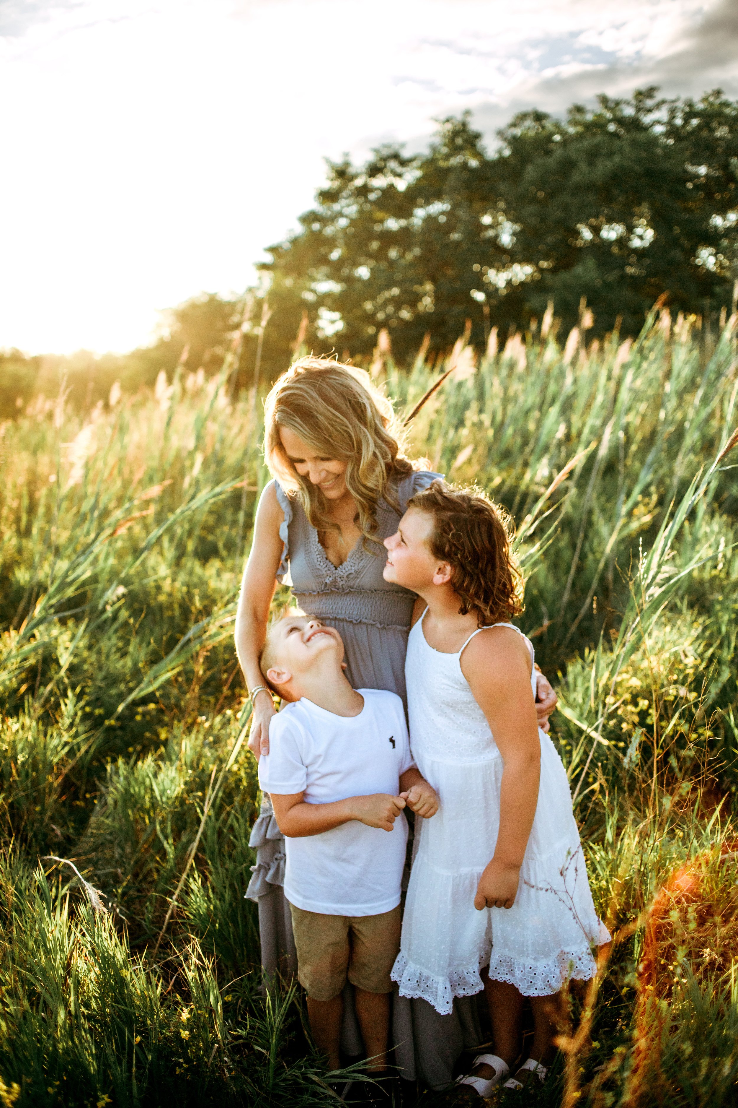  Professional family photographer Teala Ward Photography captures a small family laughing as the sun sets behind them. Illinois fam pics #motherhood #mommapics #TealaWardPhotography #TealaWardFamilies #IllinoisPhotographers #IllinoisFamilyPhotography