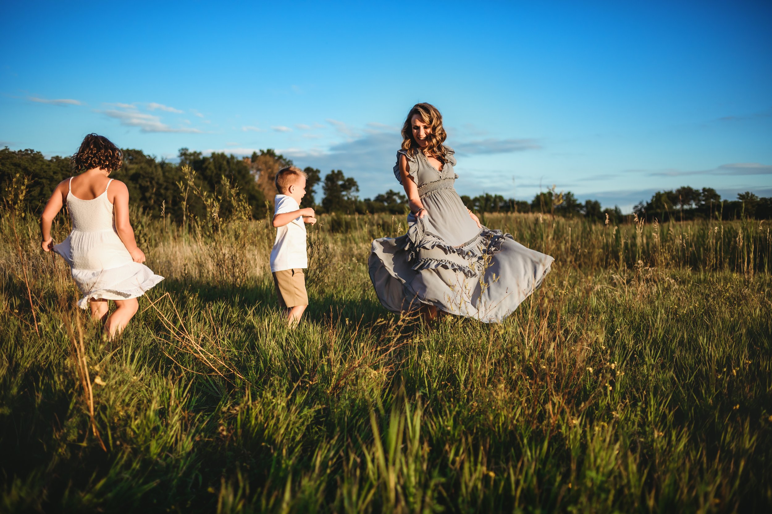  Teala Ward Photography captures a mother and her children dancing in an Illinois Meadow at dusk. Dancing family pictures Illinois #motherhood #mommapics #TealaWardPhotography #TealaWardFamilies #IllinoisPhotographers #IllinoisFamilyPhotography 