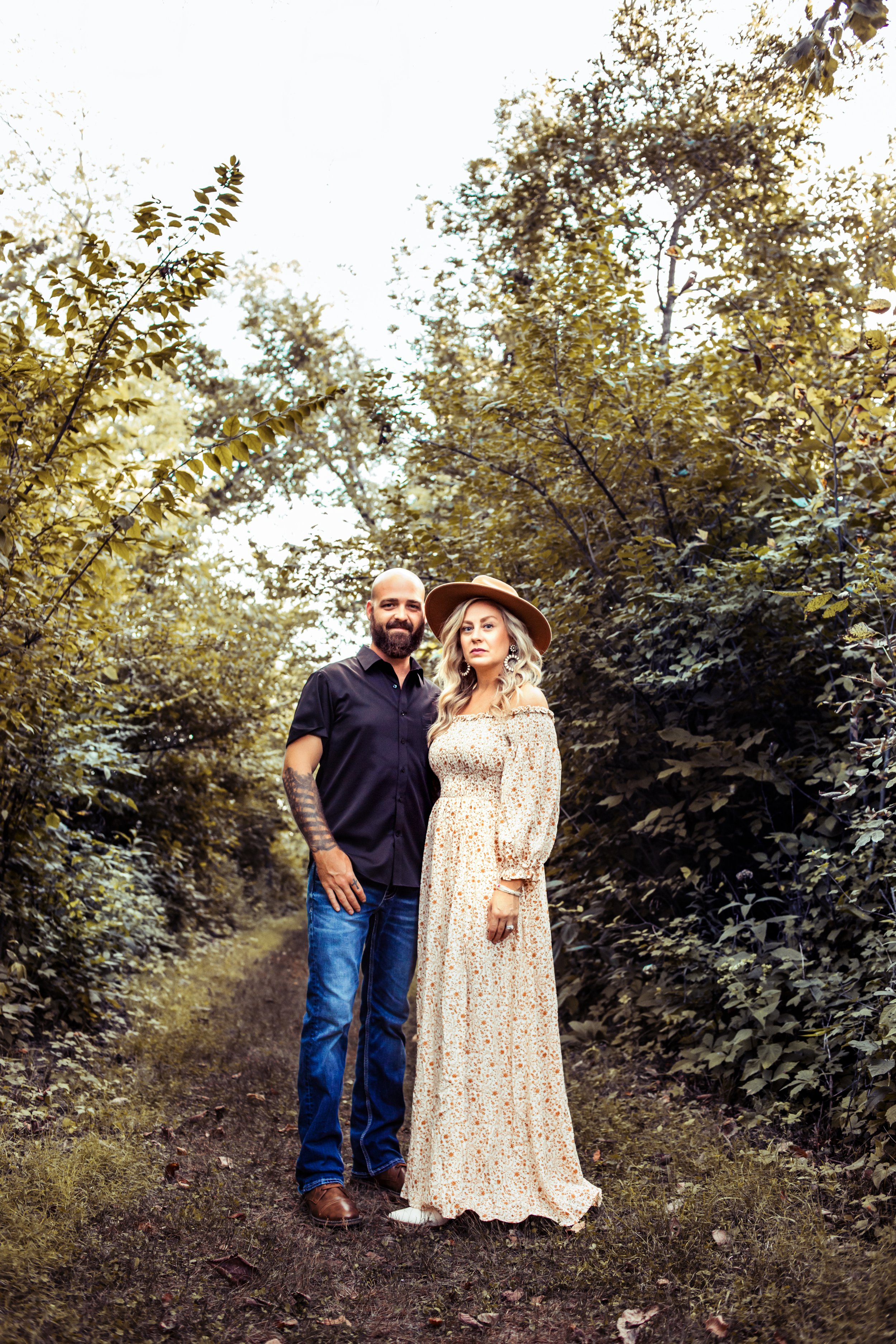  Husband and wife wearing boho vibe outfits in a garden path taken by Teala Ward Photography. boho outfit ideas fam pics #TealaWardPhotography #IllinoisValleyPhotographer #midwestphotography #TealaWardFamilies #Illinoisfamilypictures 