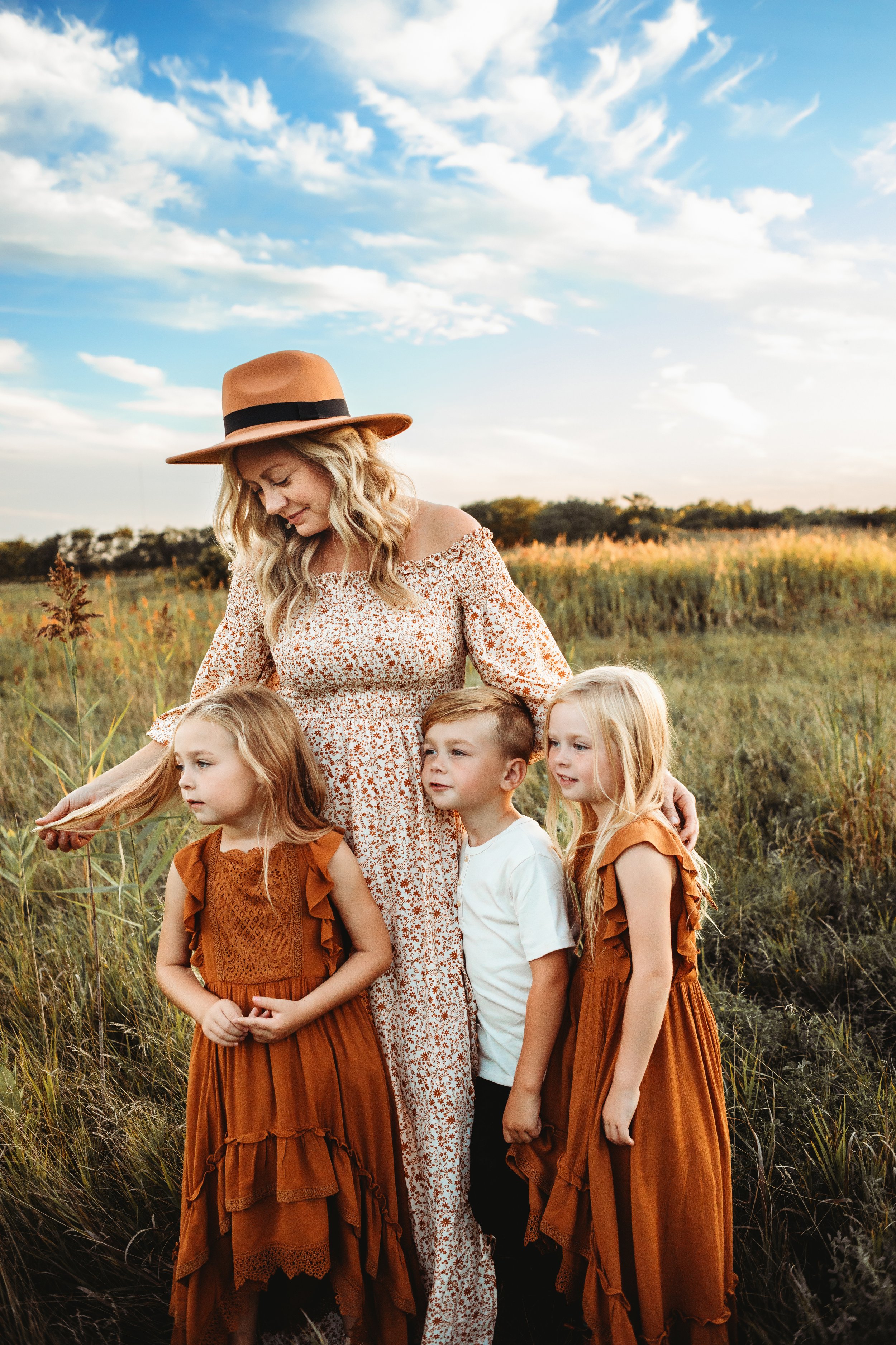  A mother with her three young children in a yellow prairie by Teala Ward Photography. yellow grass fam pic young kid fam pic #TealaWardPhotography #IllinoisValleyPhotographer #midwestphotography #TealaWardFamilies #Illinoisfamilypictures 