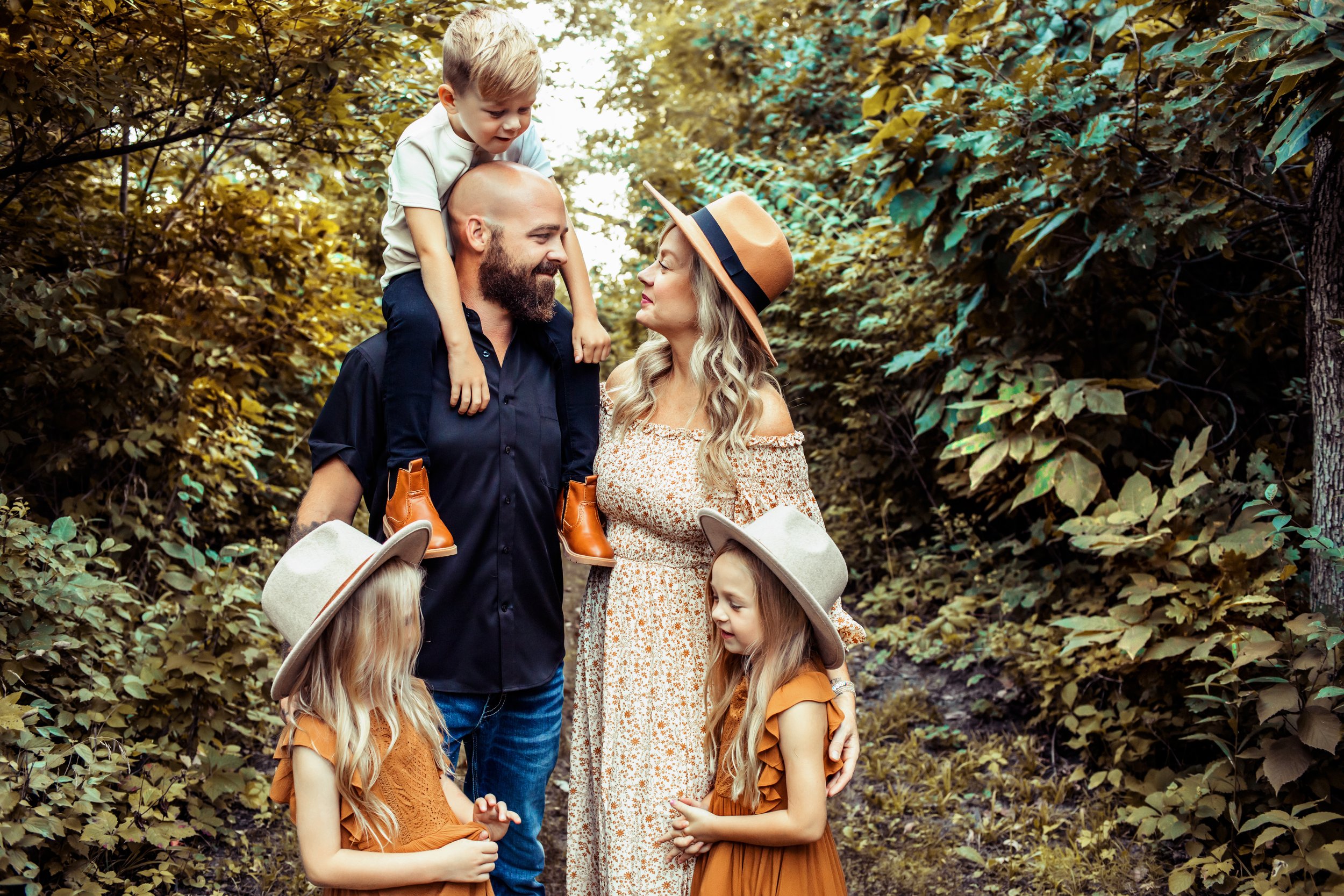  A family with three young kids and the girls wearing hats for a boho portrait by Teala Ward Photography. boho family pics girls in hats #TealaWardPhotography #IllinoisValleyPhotographer #midwestphotography #TealaWardFamilies #Illinoisfamilypictures 