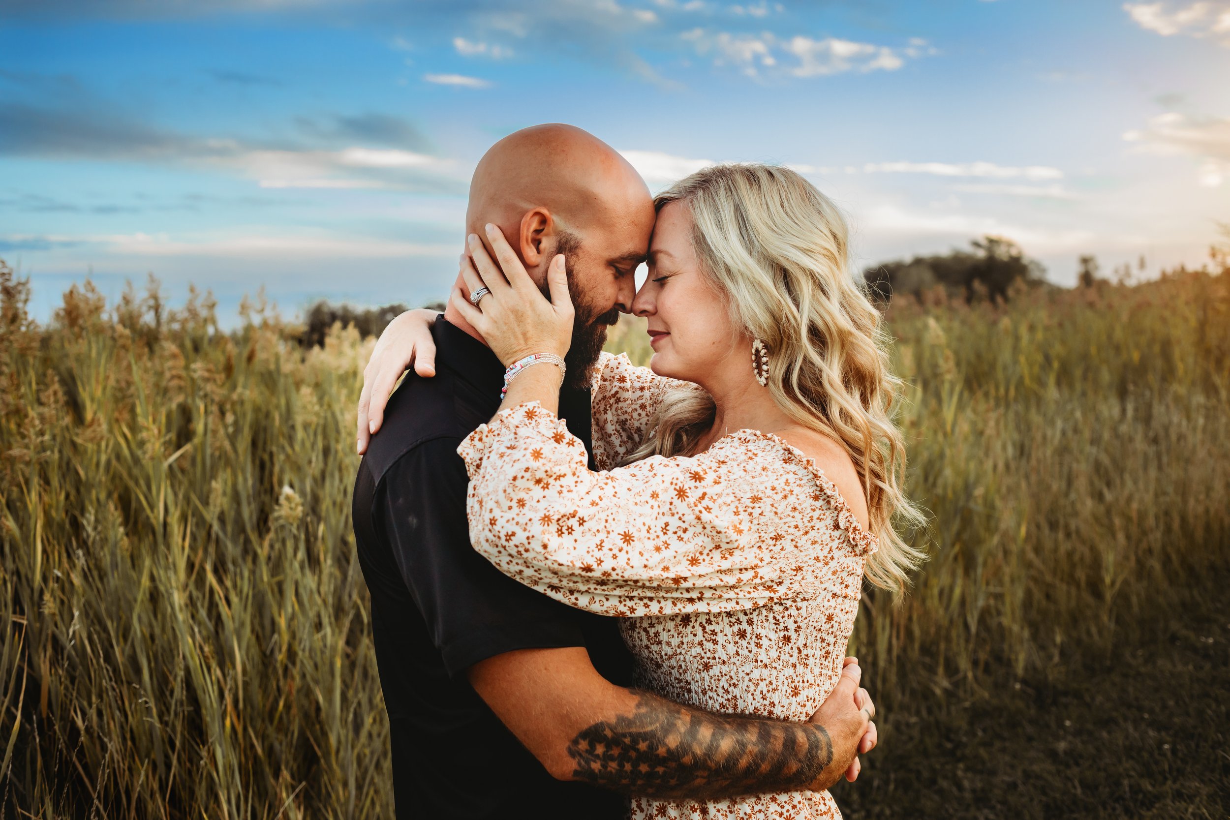  Blue skies at dusk with a man and woman snuggling by Teala Ward Photography in Illinois. Illinois Family Photographers husband and wife #TealaWardPhotography #IllinoisValleyPhotographer #midwestphotography #TealaWardFamilies #Illinoisfamilypictures 