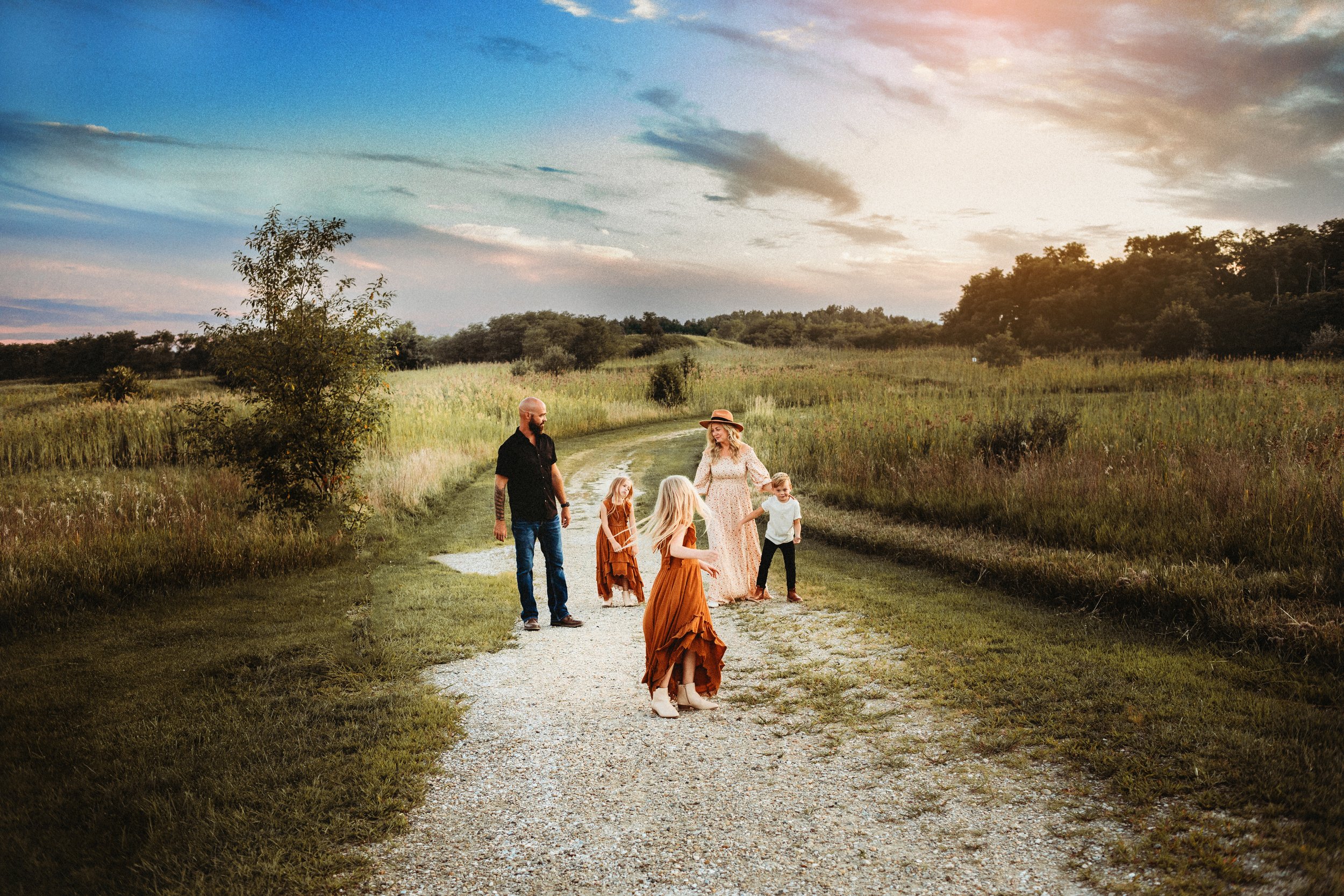  In a grass field in Illinois, a family of five plays a game together captured by Teala Ward Photography. moody family pics #TealaWardPhotography #IllinoisValleyPhotographer #midwestphotography #TealaWardFamilies #Illinoisfamilypictures 