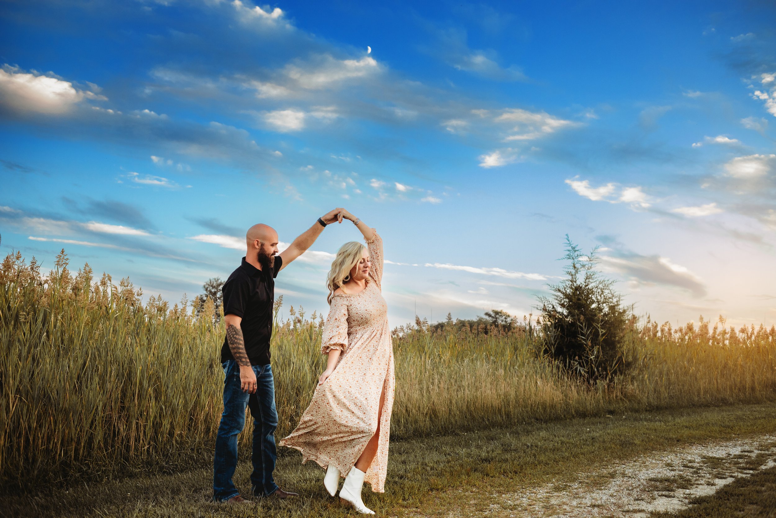  A husband twirls his wife around under a blue sky captured by Teala Ward Photography. professional family photographer Illinois #TealaWardPhotography #IllinoisValleyPhotographer #midwestphotography #TealaWardFamilies #Illinoisfamilypictures 