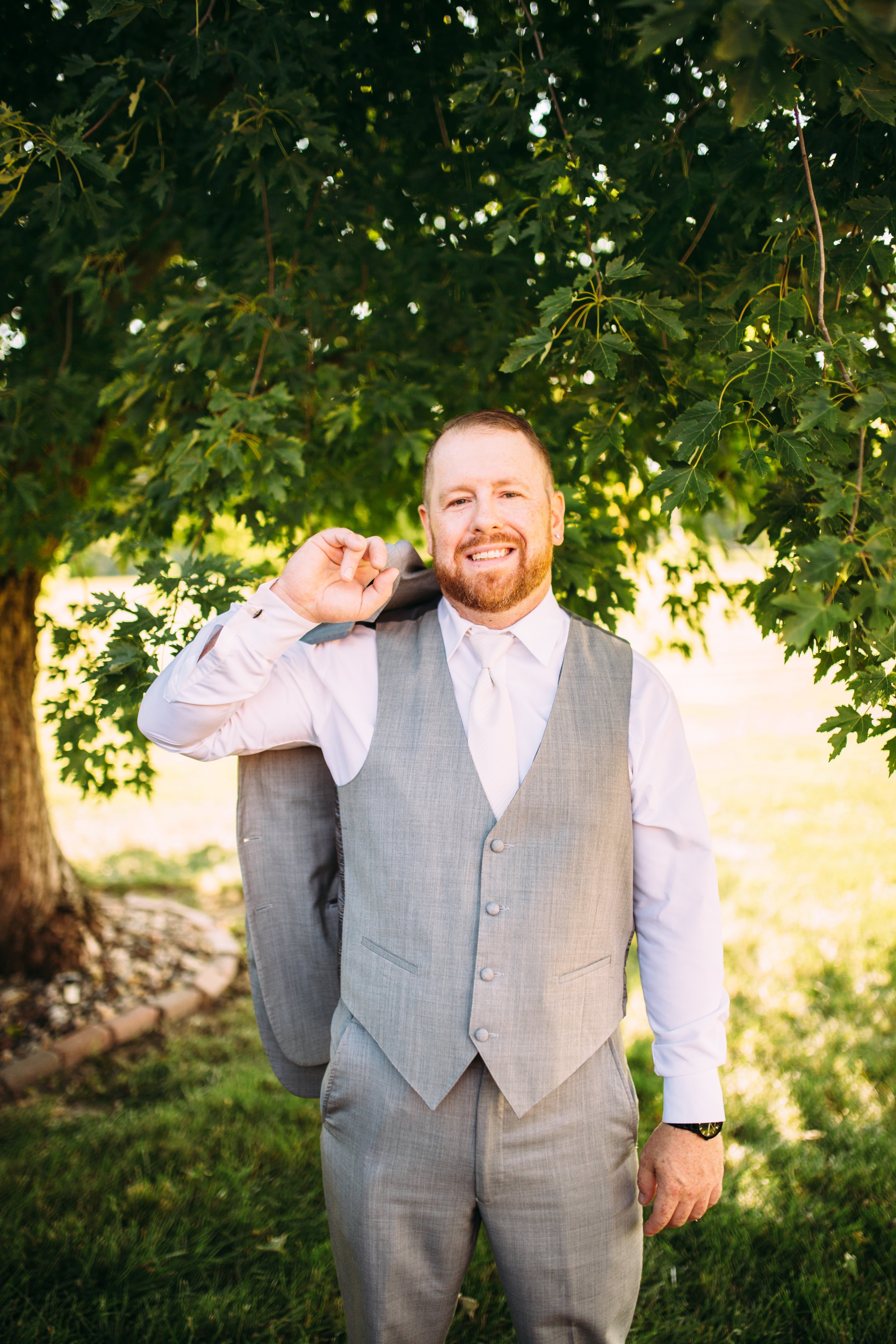  Teala Ward Photography captures a portrait of the groom in a gray three-piece suit on his wedding day. groom style groom portrait #TealaWardPhotography #IllinoisValleyPhotographer #summerwedding #TealaWardWeddings #Illinoisweddings  