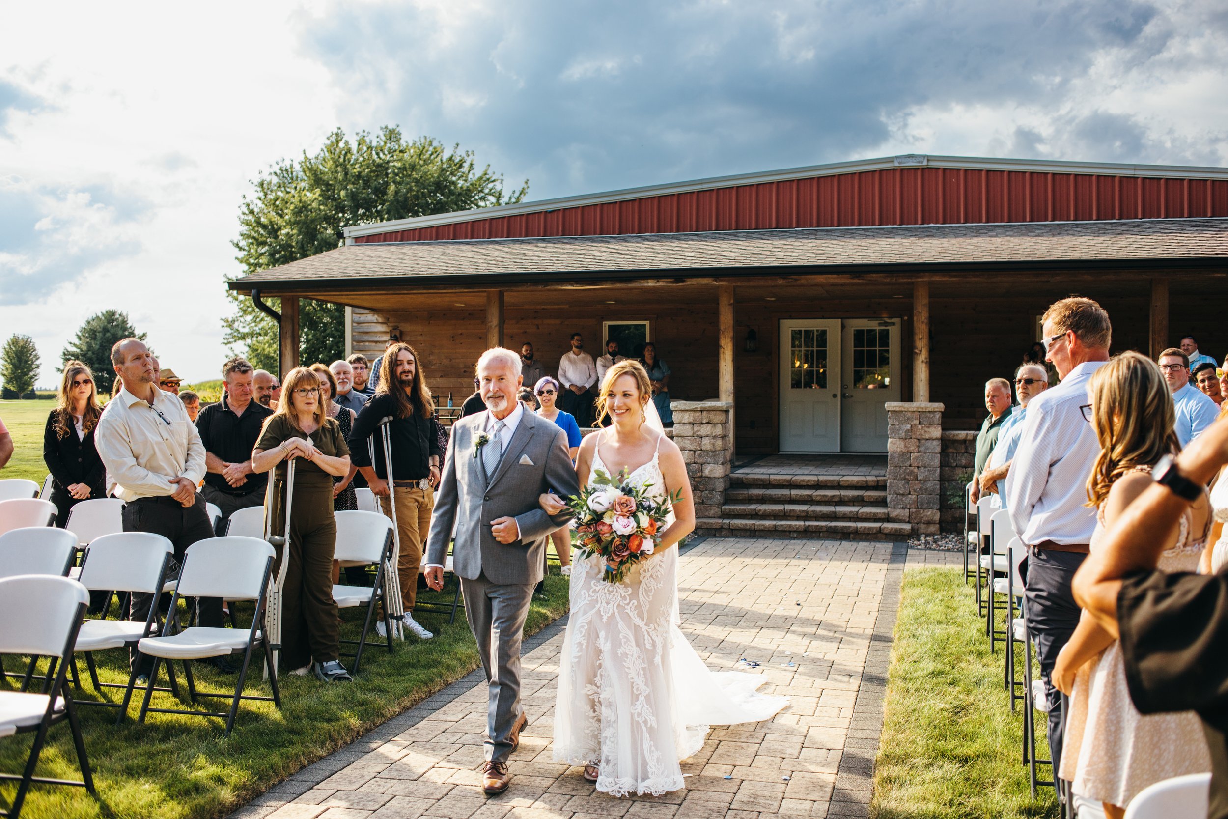  A father of the bride walks the bride down the aisle during an outdoor wedding shot by Teala Ward Photography. here comes the bride aisle #TealaWardPhotography #IllinoisValleyPhotographer #summerwedding #TealaWardWeddings #Illinoisweddings  