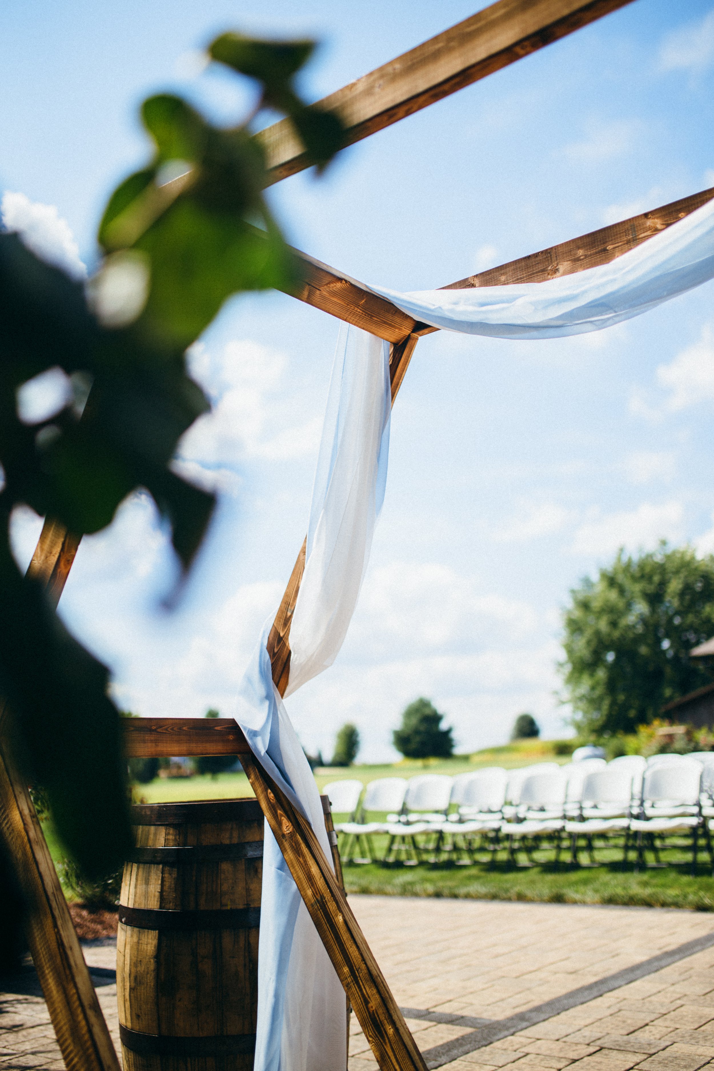  Detailed photo of a wedding altar strewn with white fabric and fresh florals by Teala Ward Photography. wedding day details altar outdoor wed #TealaWardPhotography #IllinoisValleyPhotographer #summerwedding #TealaWardWeddings #Illinoisweddings  