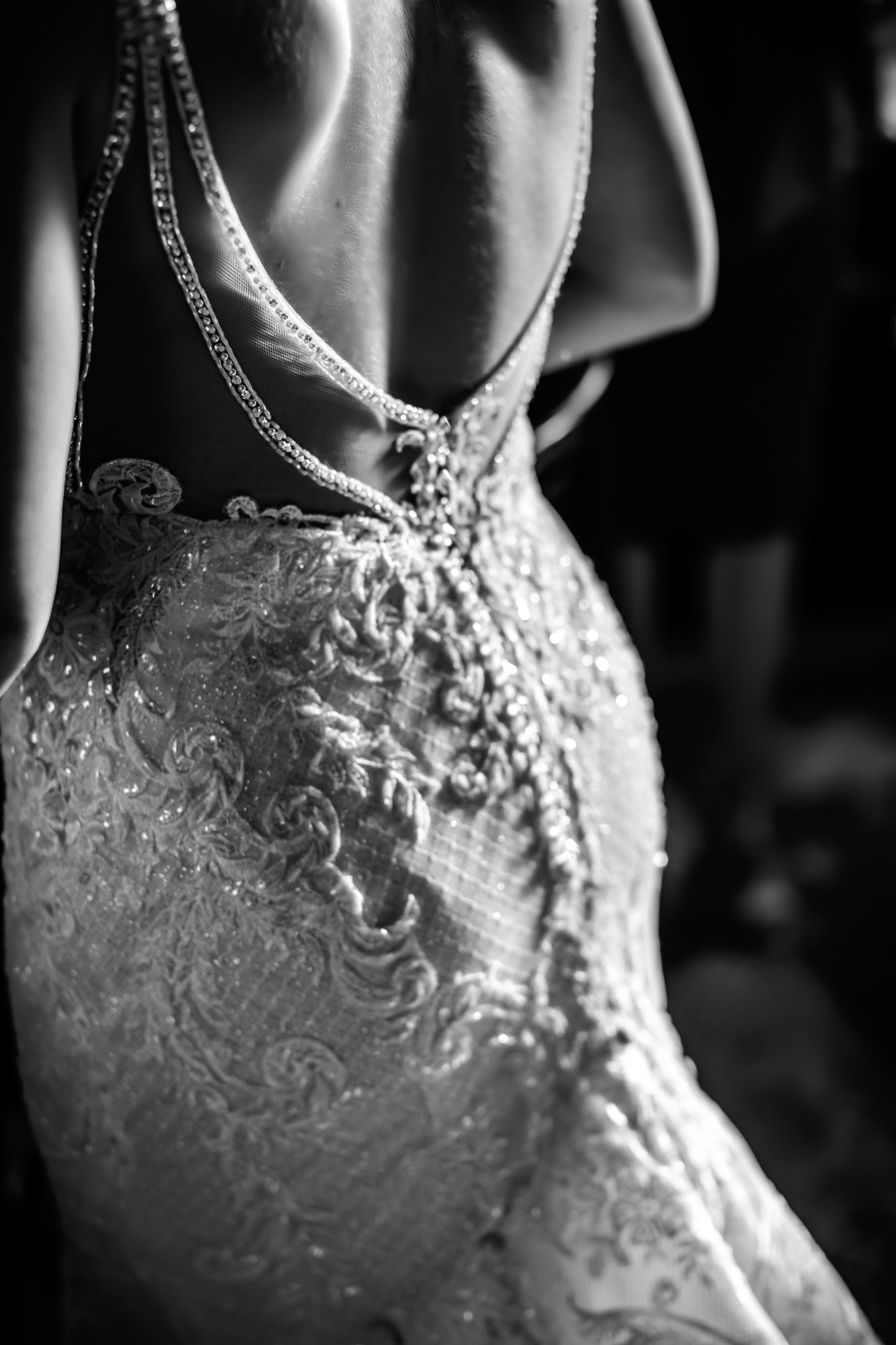  Illinois wedding photographer captures a detailed shot of the back of a wedding gown in black and white. wedding details #TealaWardPhotography #TealaWardWeddings #WeddingLocationsIllinois #IllinoisWedding #weddingdetails #weddingphotography #married