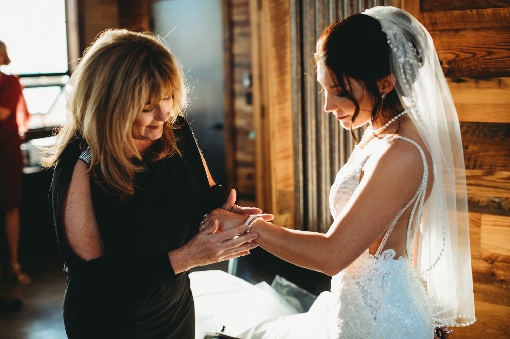  Teala Ward Photography captures the mother of the bride helping the bride with her jewelry. mother of bride #TealaWardPhotography #TealaWardWeddings #WeddingLocationsIllinois #IllinoisWedding #weddingdetails #weddingphotography #married 