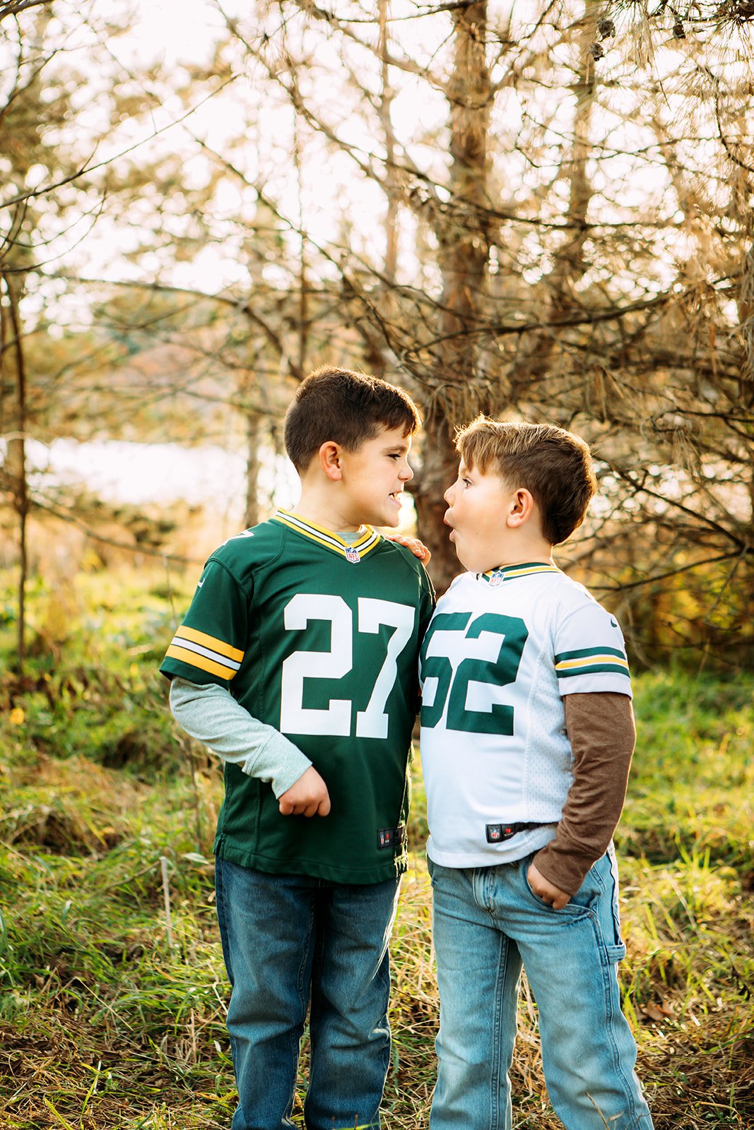  Two brothers wearing football jerseys and making silly faces at one another by Teala Ward Photography. football jersey brothers #TealaWardPhotography #TealaWardFamilies #holidayfamilypics #photography #Illinoisfamilyphotography #familysession 